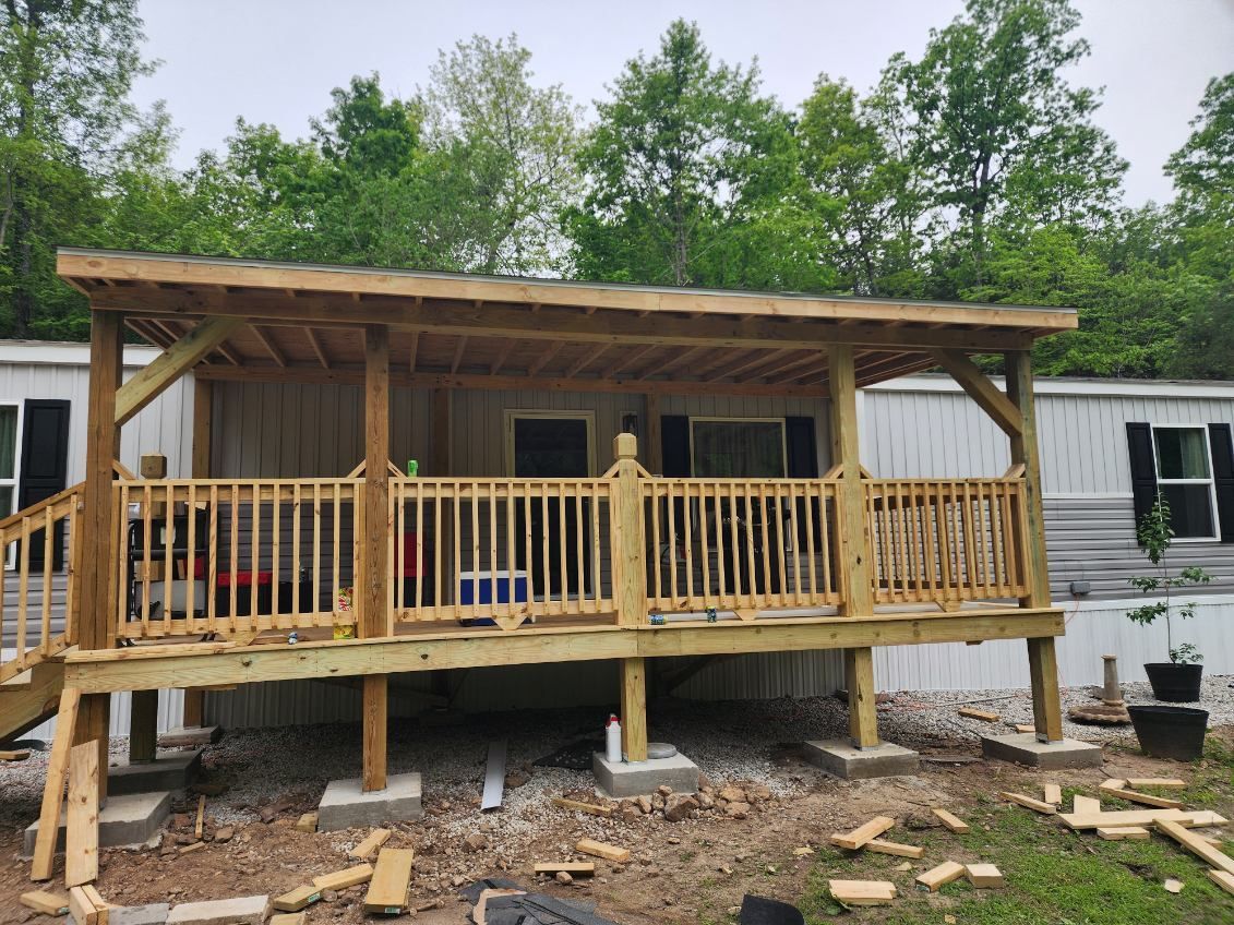 A newly built wooden porch with a roof extension on a mobile home.
