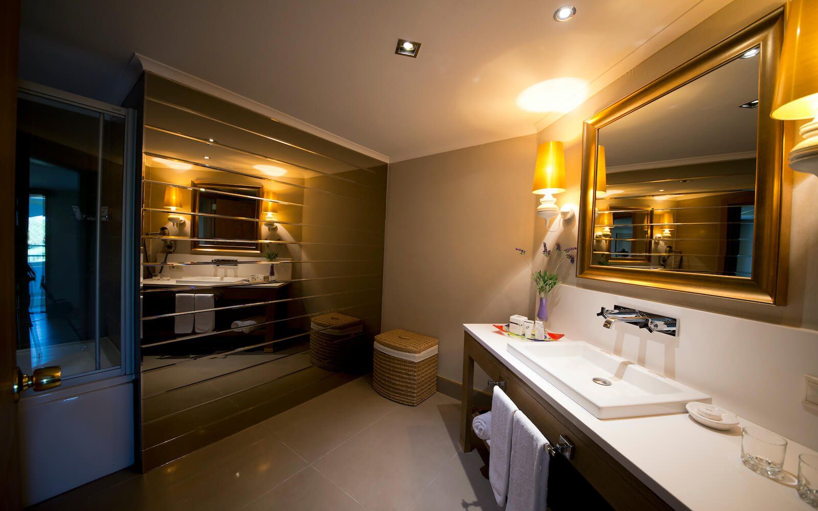 Ein Badezimmer mit Waschbecken, Spiegel und Fernseher.