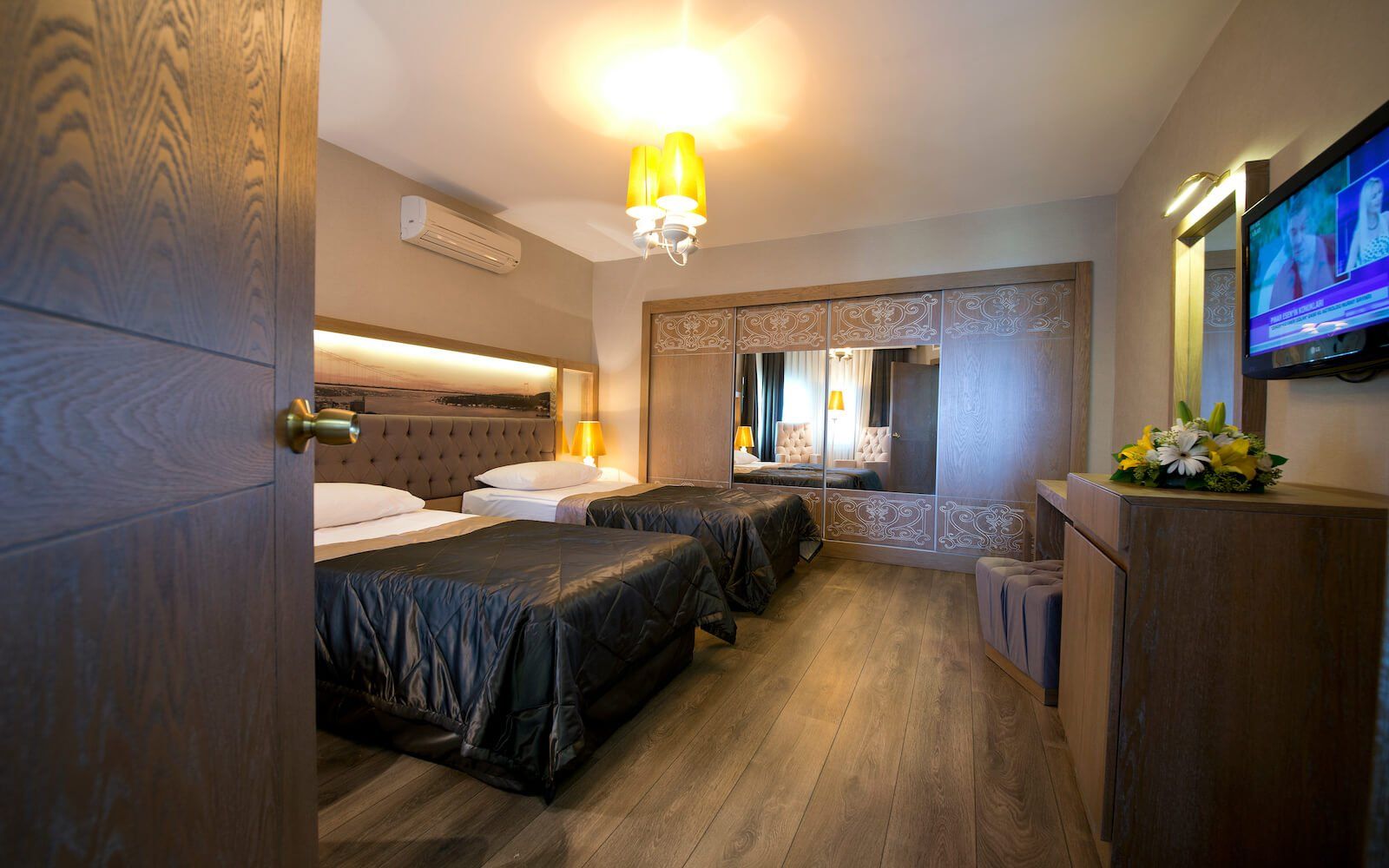 Ein Hotelzimmer mit zwei Betten und einem Flachbildfernseher.