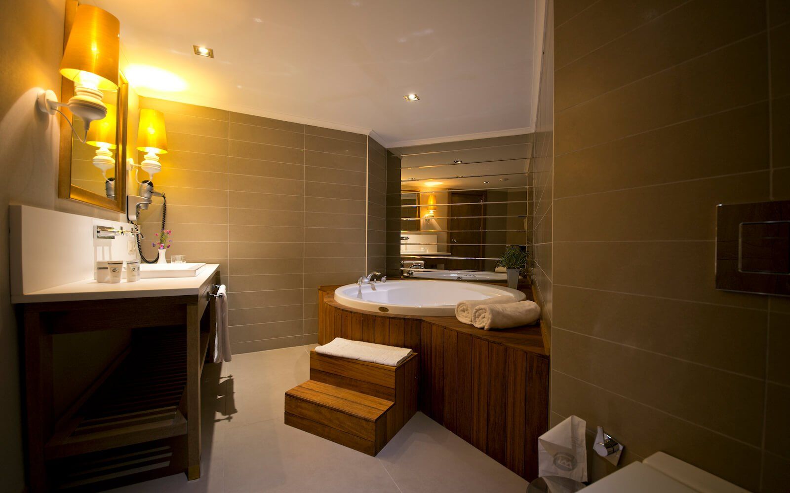 Ein Badezimmer mit Whirlpoolwanne, Waschbecken, Toilette und Spiegel.