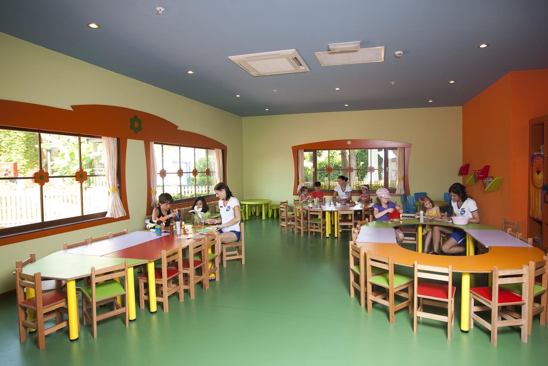 A group of children are sitting at tables in a classroom.