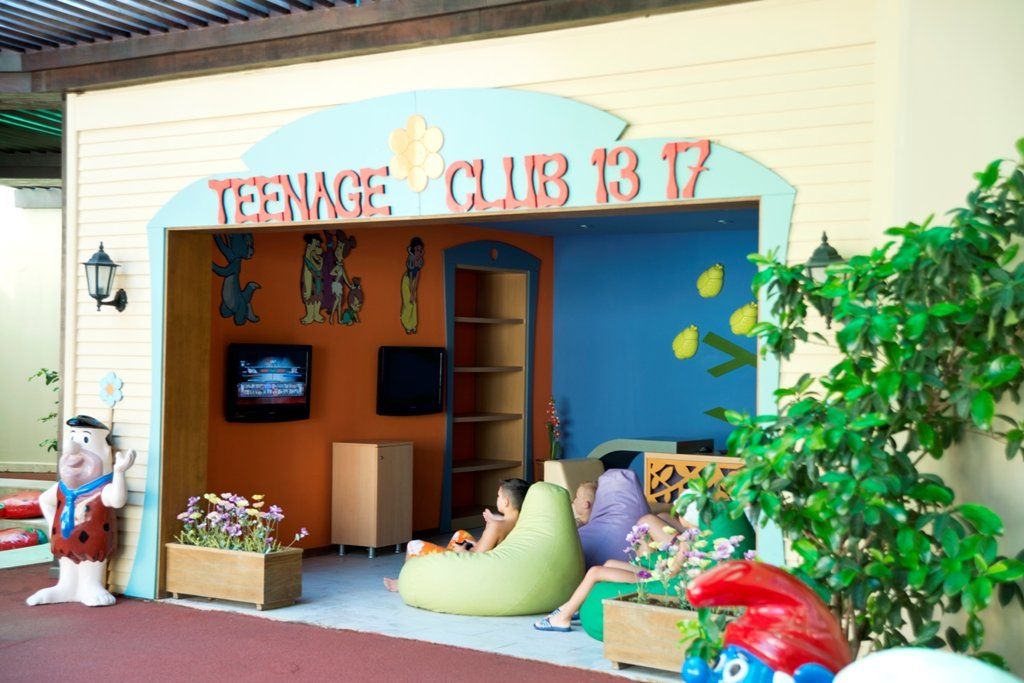 A group of children are sitting in a teenage club