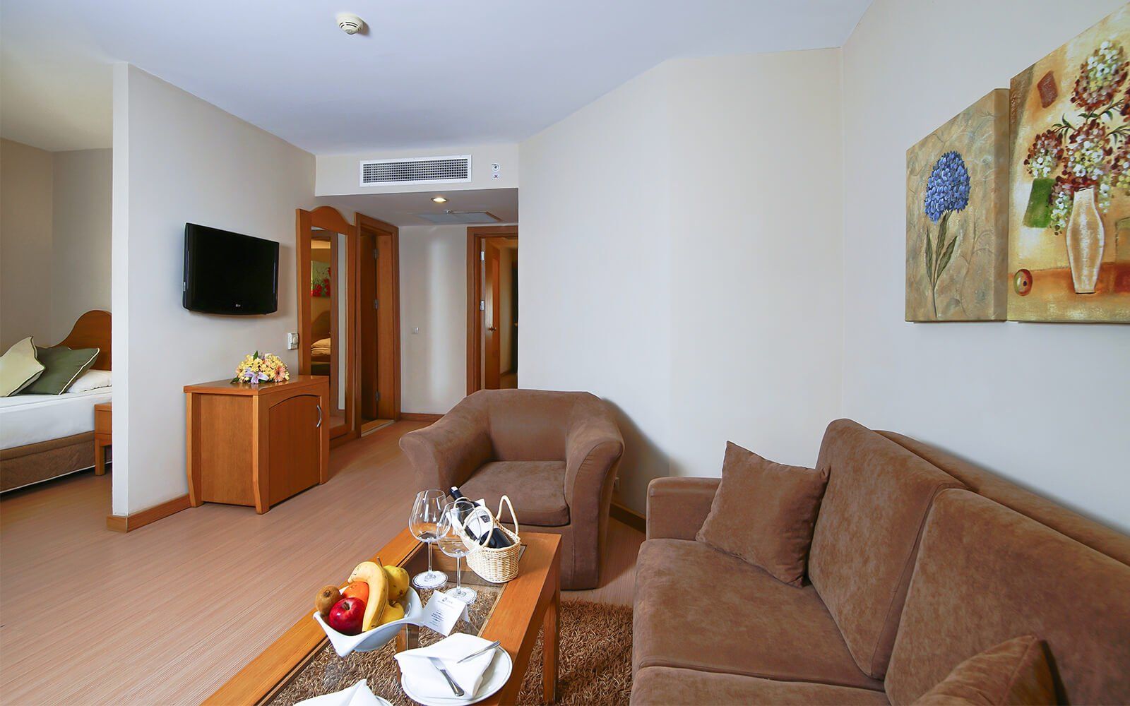 Ein Wohnzimmer mit Couch, Sessel, Couchtisch und Fernseher.