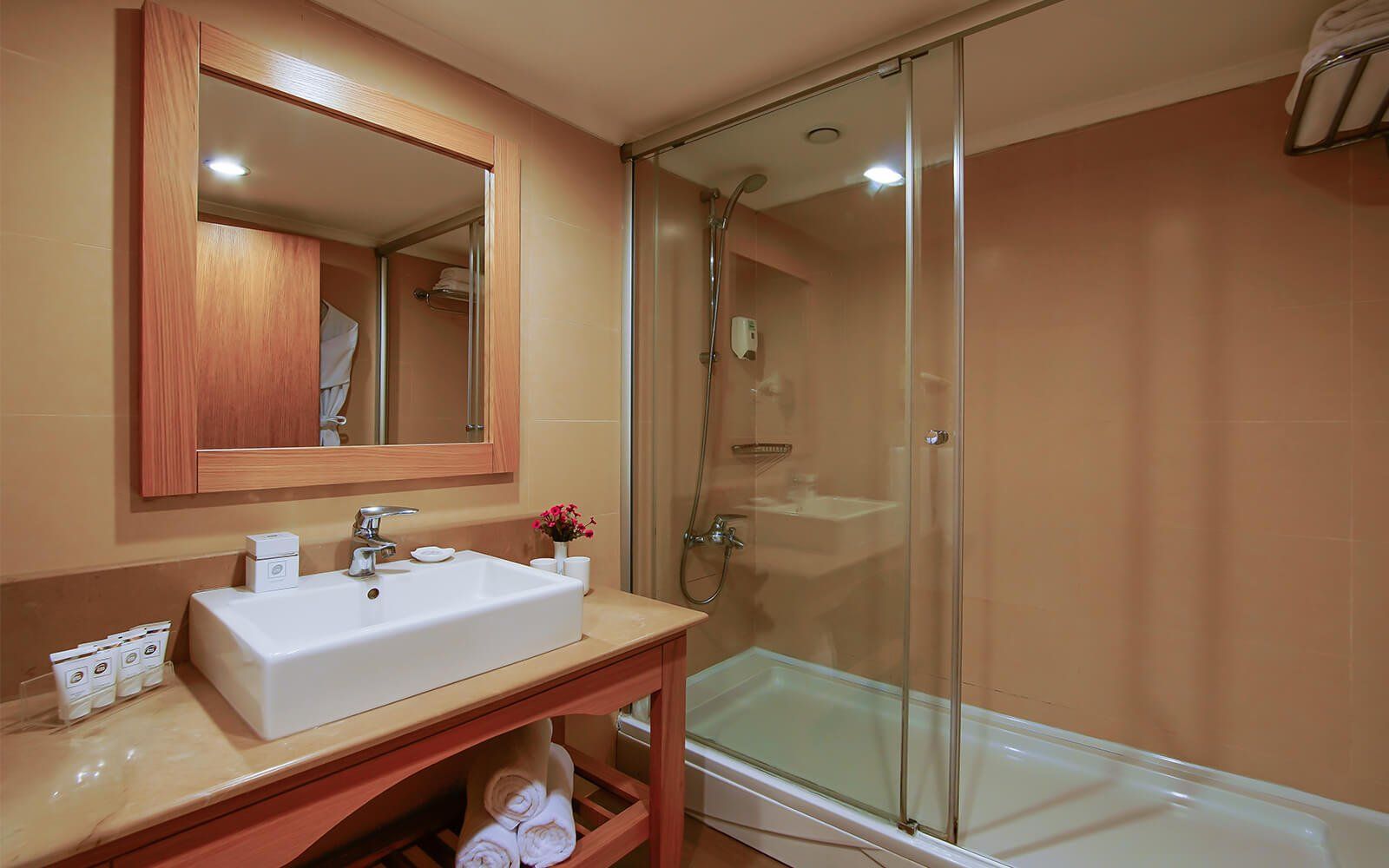 Ein Badezimmer mit Waschbecken, Spiegel, Badewanne und Dusche.