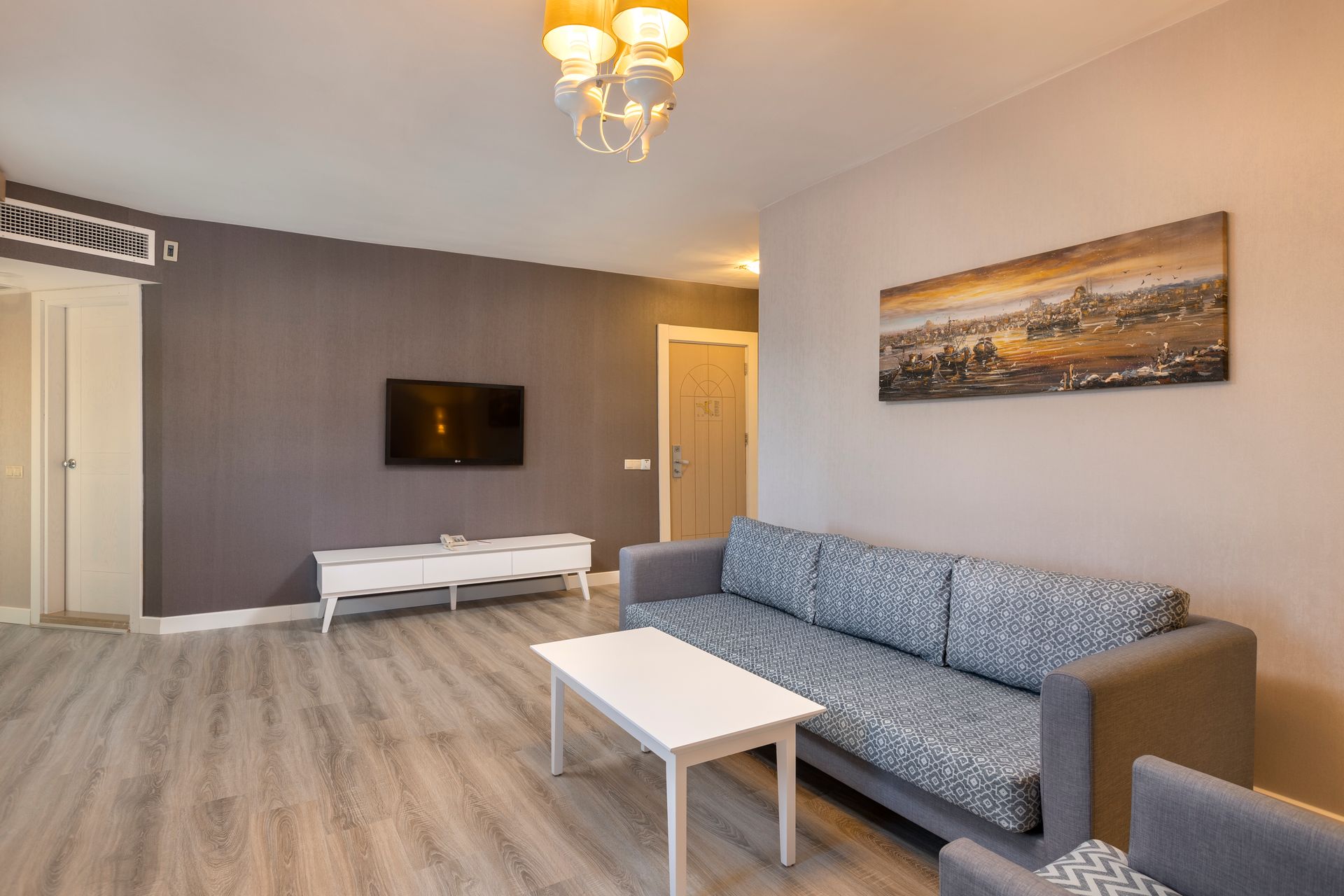 A living room with a couch , chair , table and television.