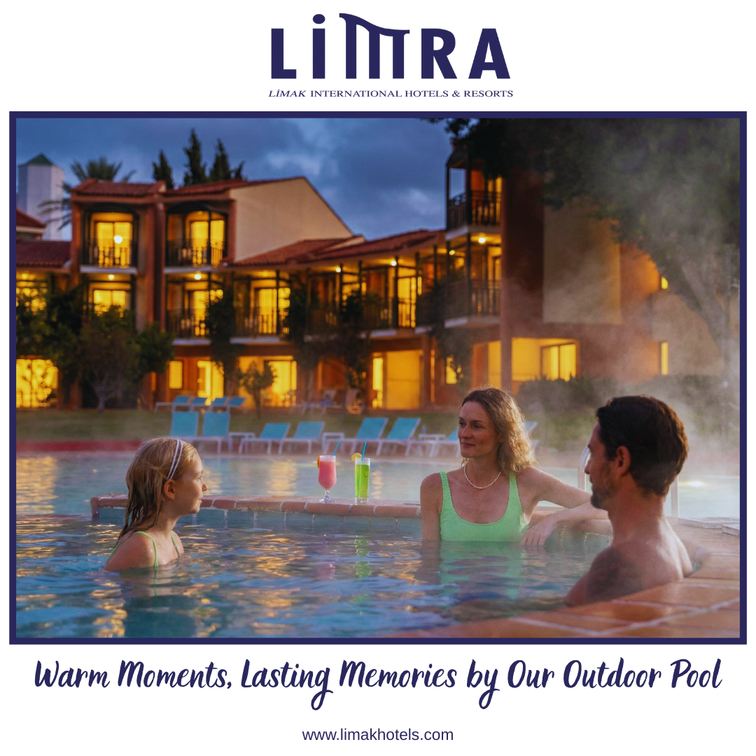 Family enjoying outdoor pool at a hotel. Warm water, cocktails. Buildings in the background. 