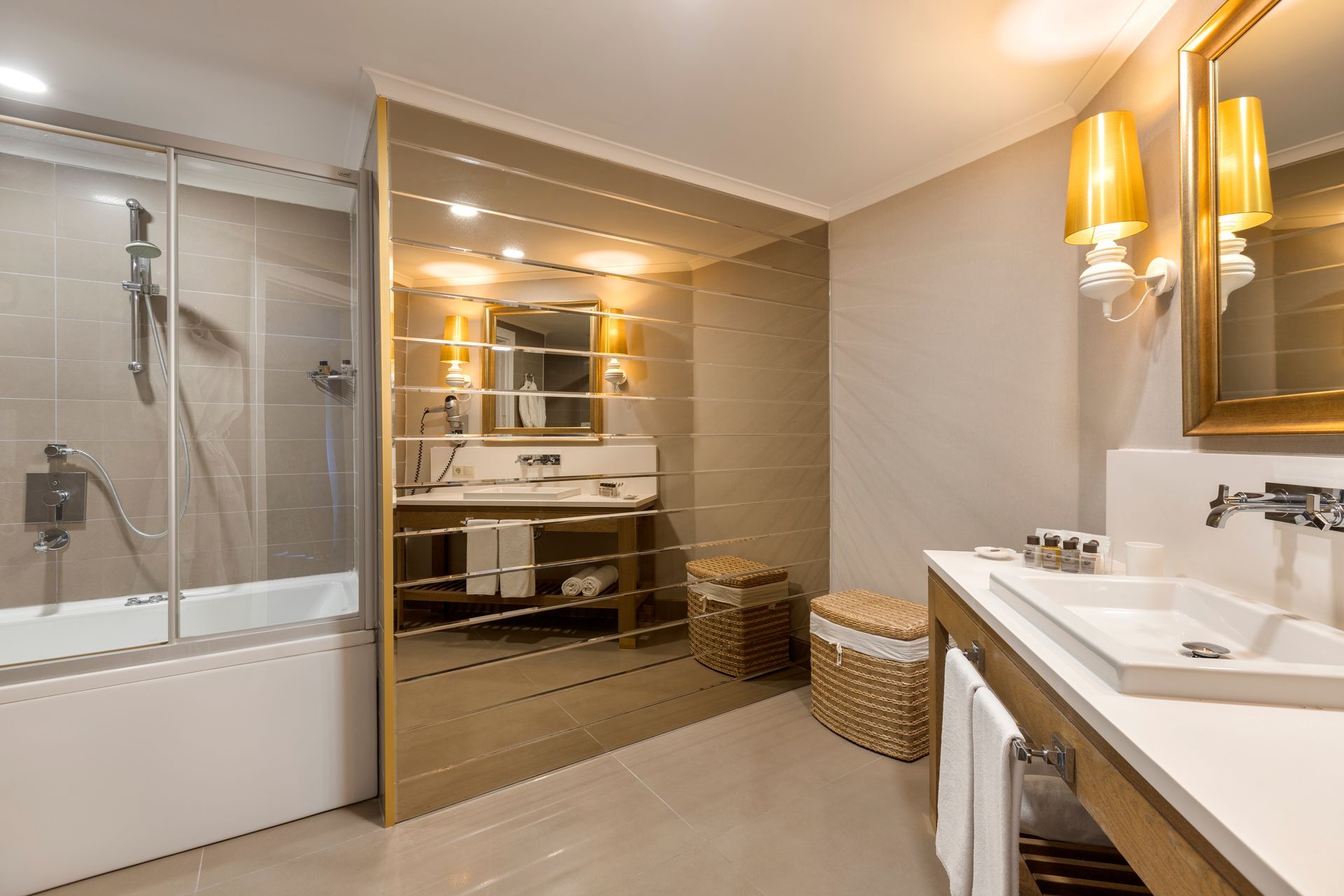 A bathroom with a sink , mirror , tub and shower.