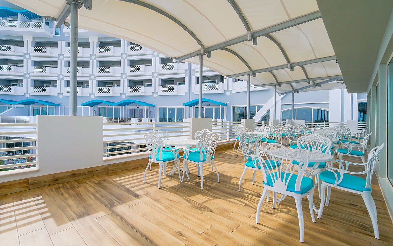 Il y a des tables et des chaises sur le balcon d'un hôtel.