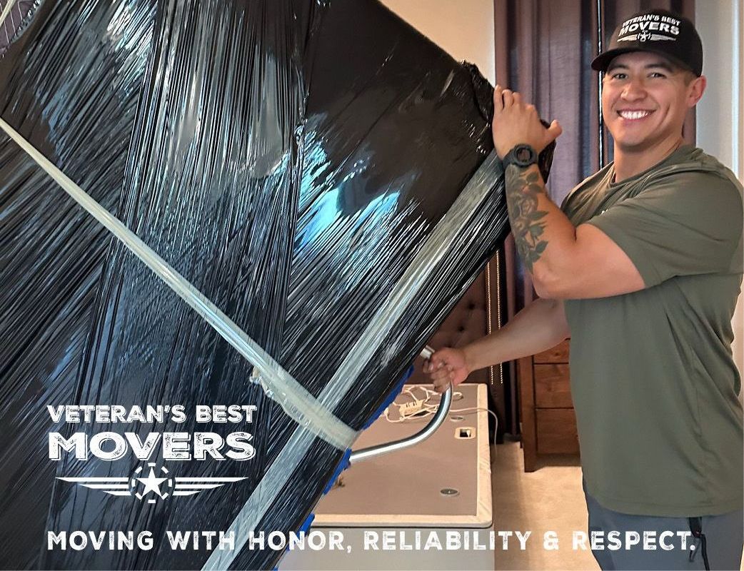 A man is wrapping a large piece of furniture in plastic wrap.