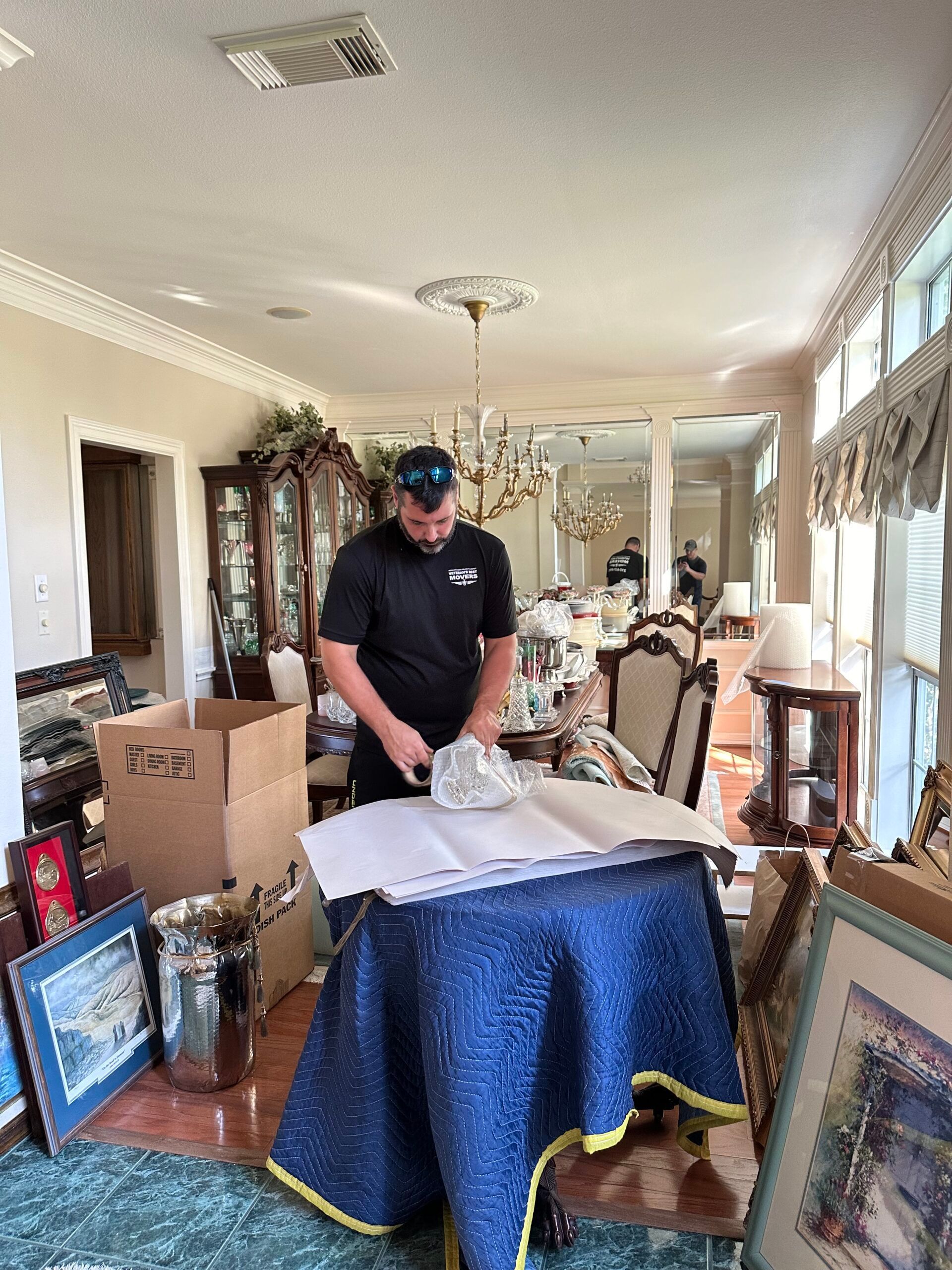 A man is standing next to a table in a living room.