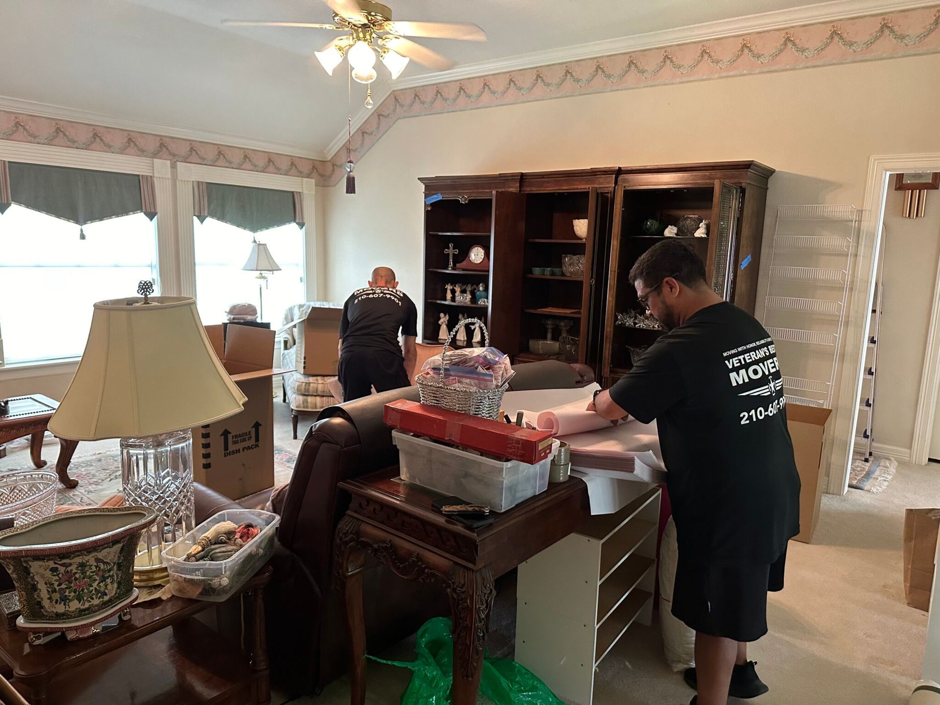 A man in a black shirt is standing in a living room.