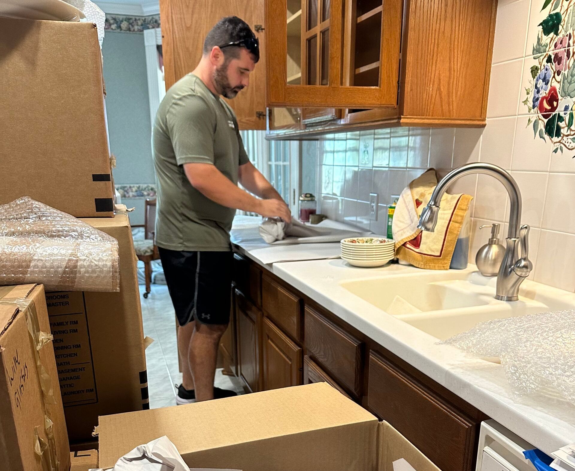 A man is standing in a kitchen preparing food