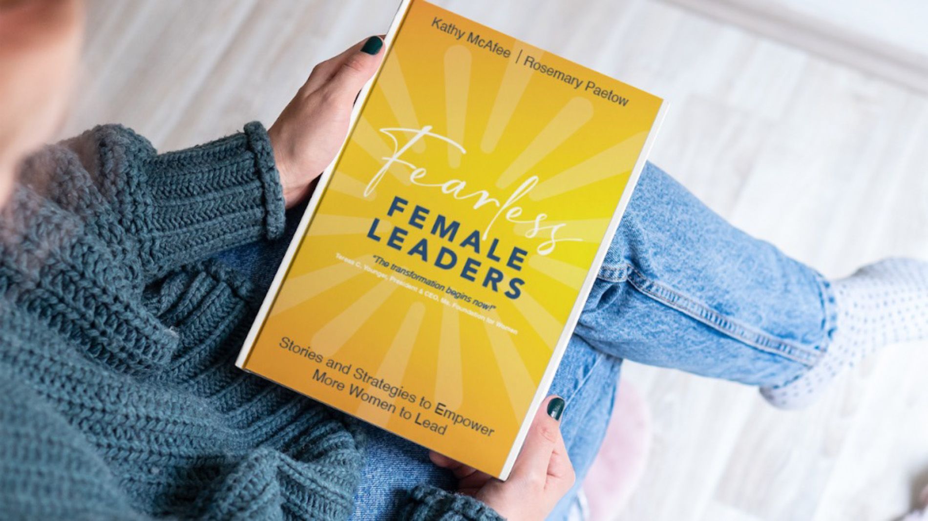 A woman is holding a book titled fearless female leaders