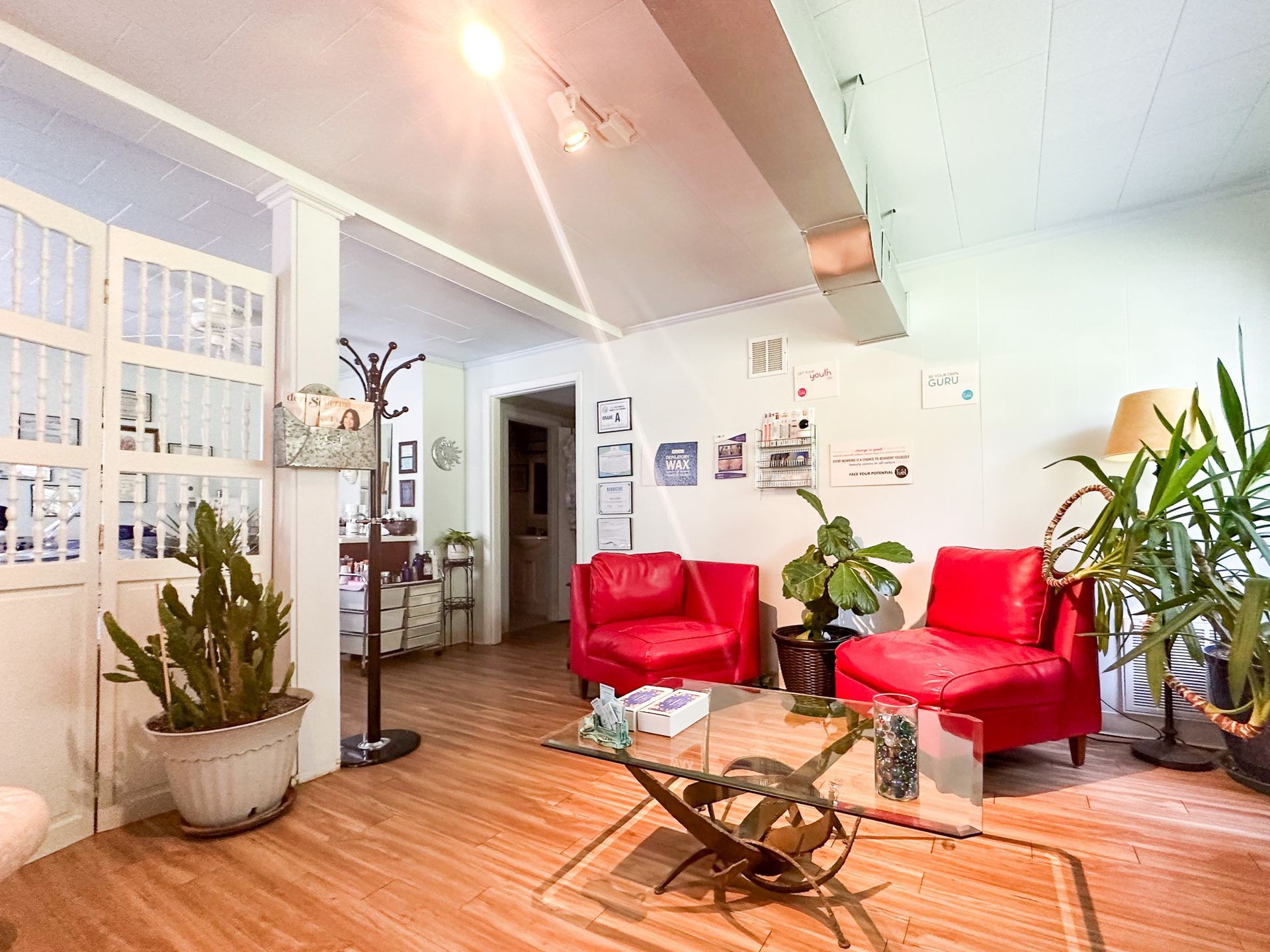A living room with red chairs and a glass coffee table.