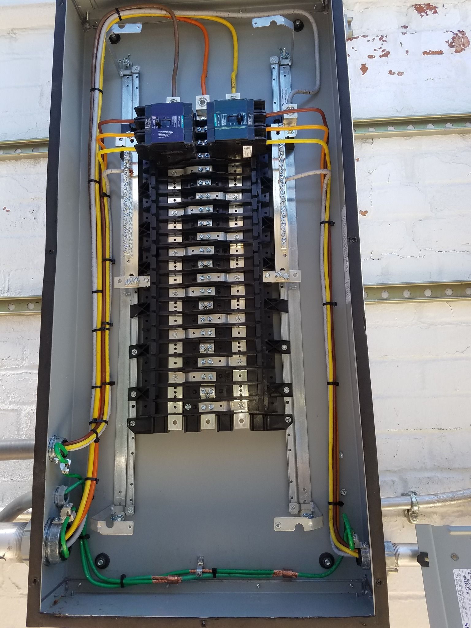 Electrical panel with circuits, wiring, and breakers inside a metal box.