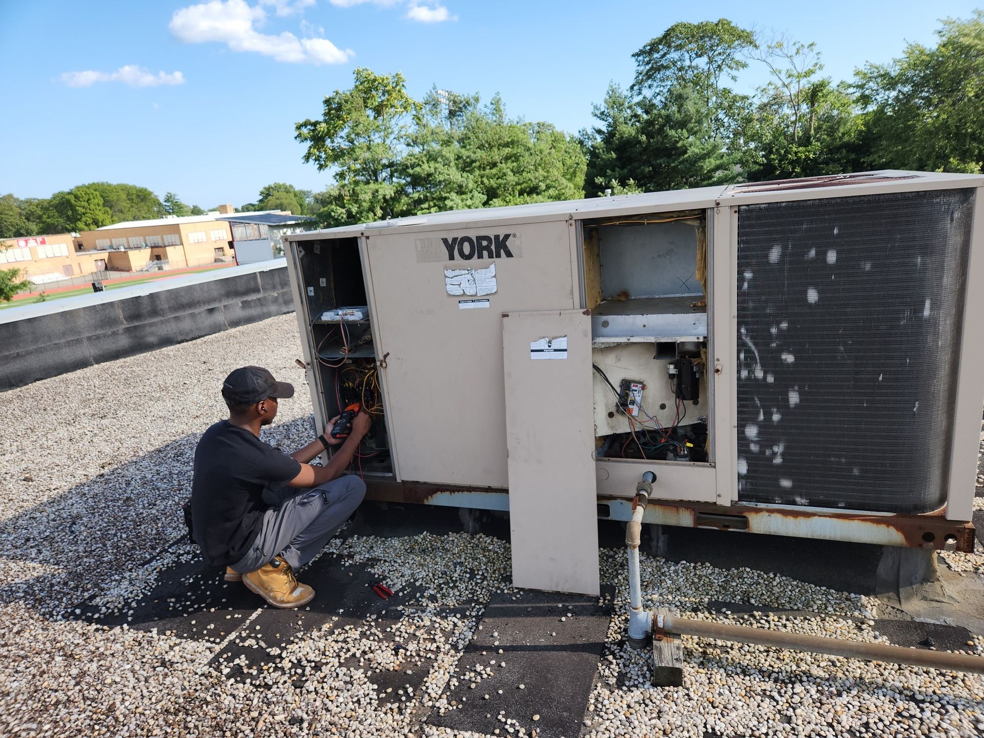 A person working on a York HVAC unit on a rooftop.