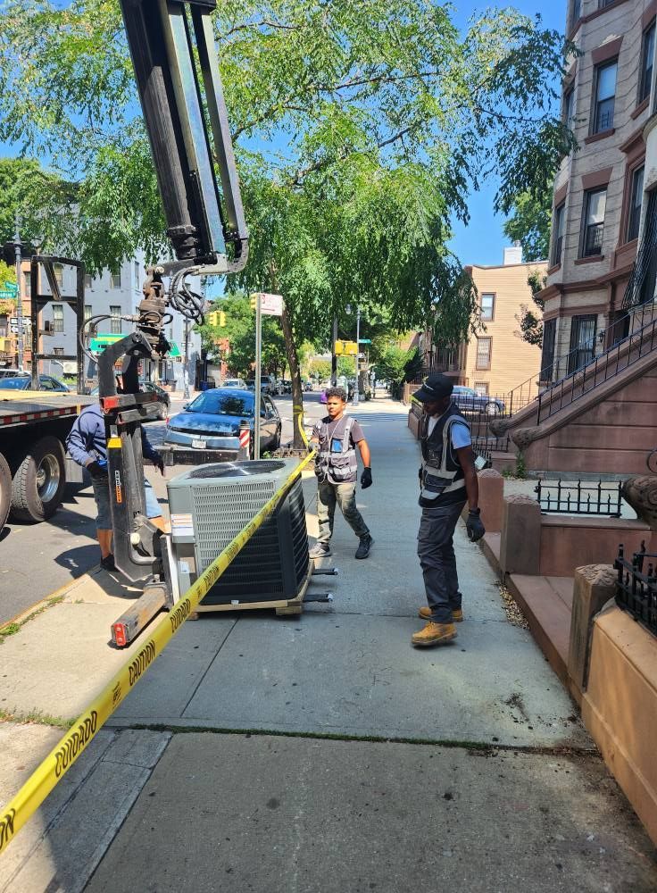 Workers unloading equipment from a truck on a city sidewalk, blocked by caution tape.