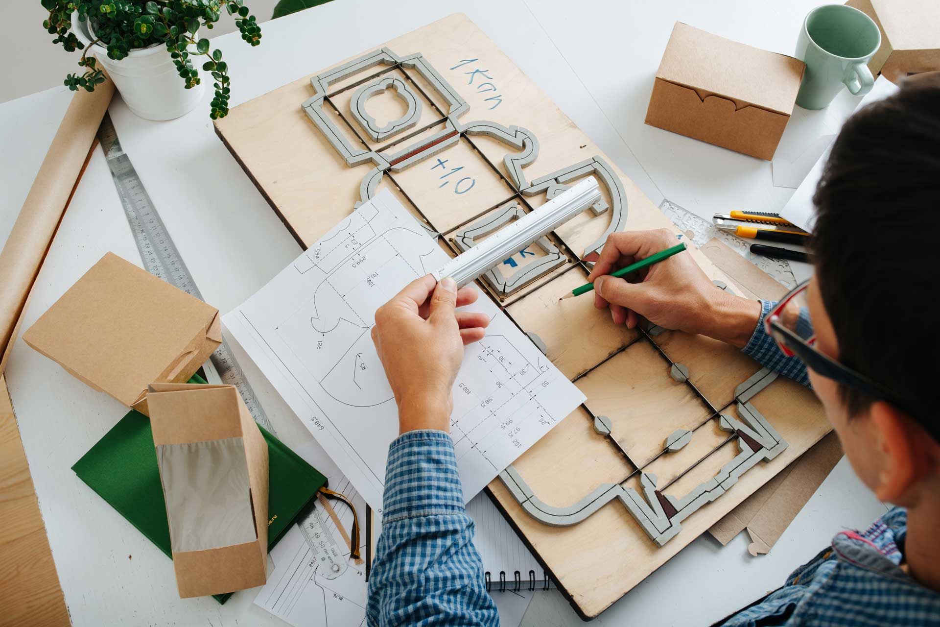 Top view of a packaging designer working on a design on a table.
