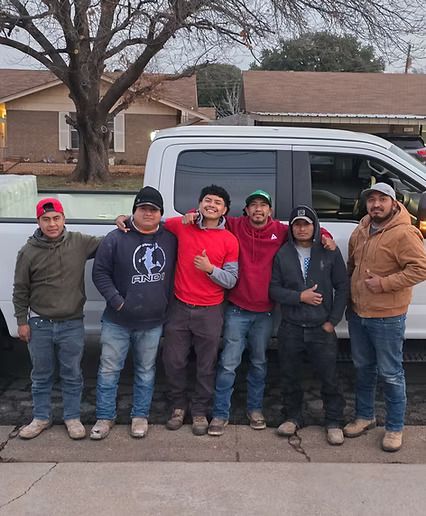 A group of men are posing for a picture in front of a truck.