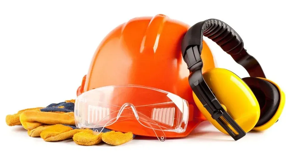 Casco naranja, gafas de seguridad, orejeras amarillas y guantes; equipo de seguridad para la construcción.