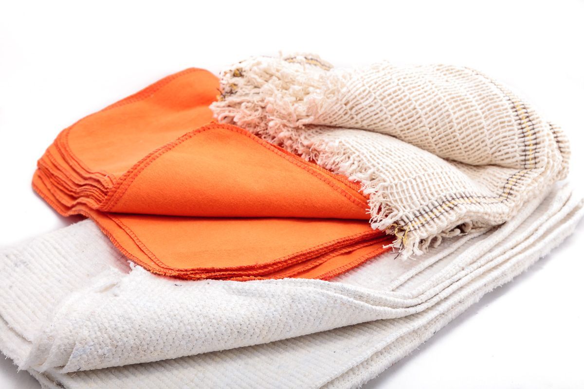 Paños doblados de color naranja y beige, apilados.