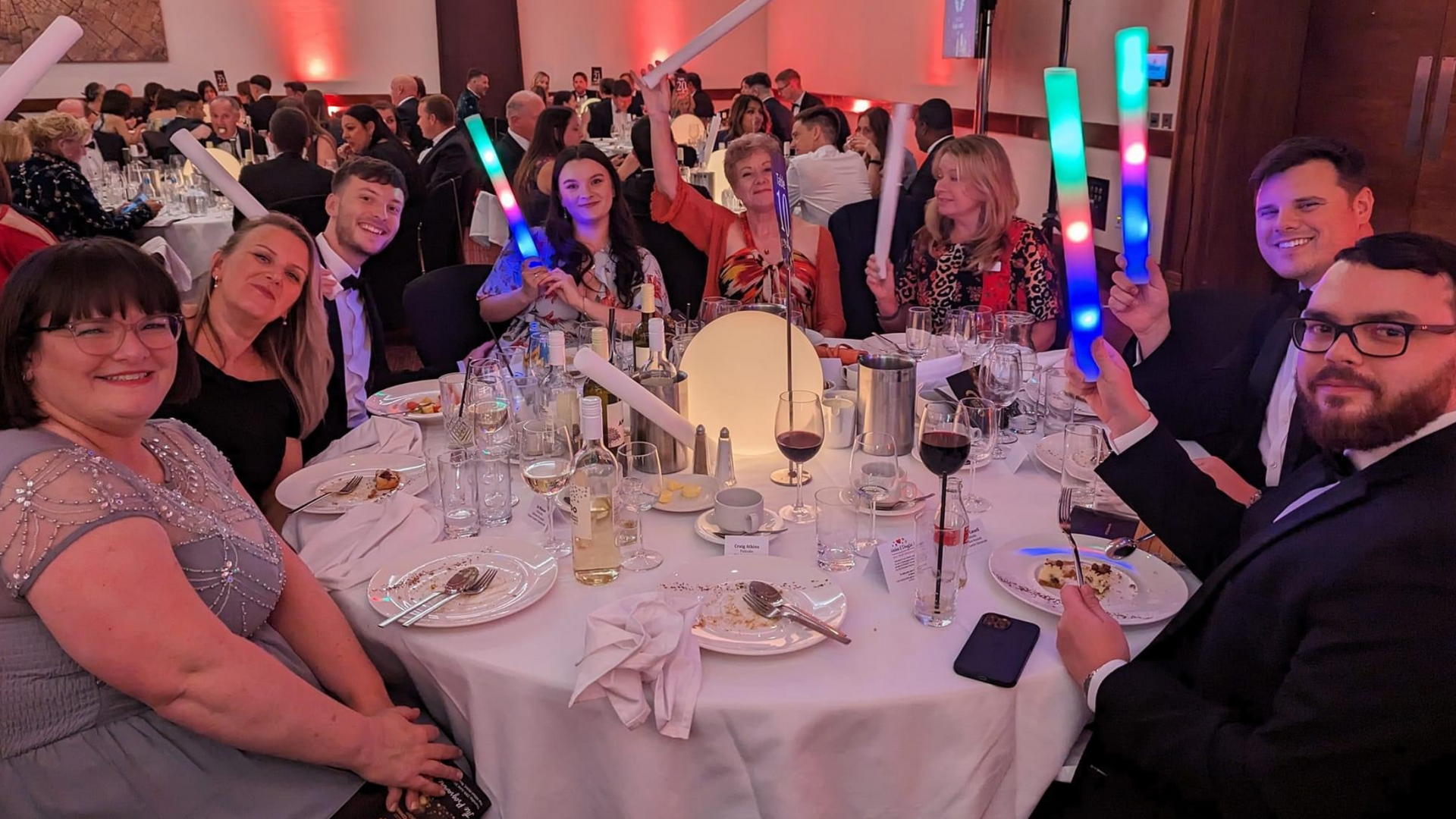 A group of people are sitting at a table at a party.