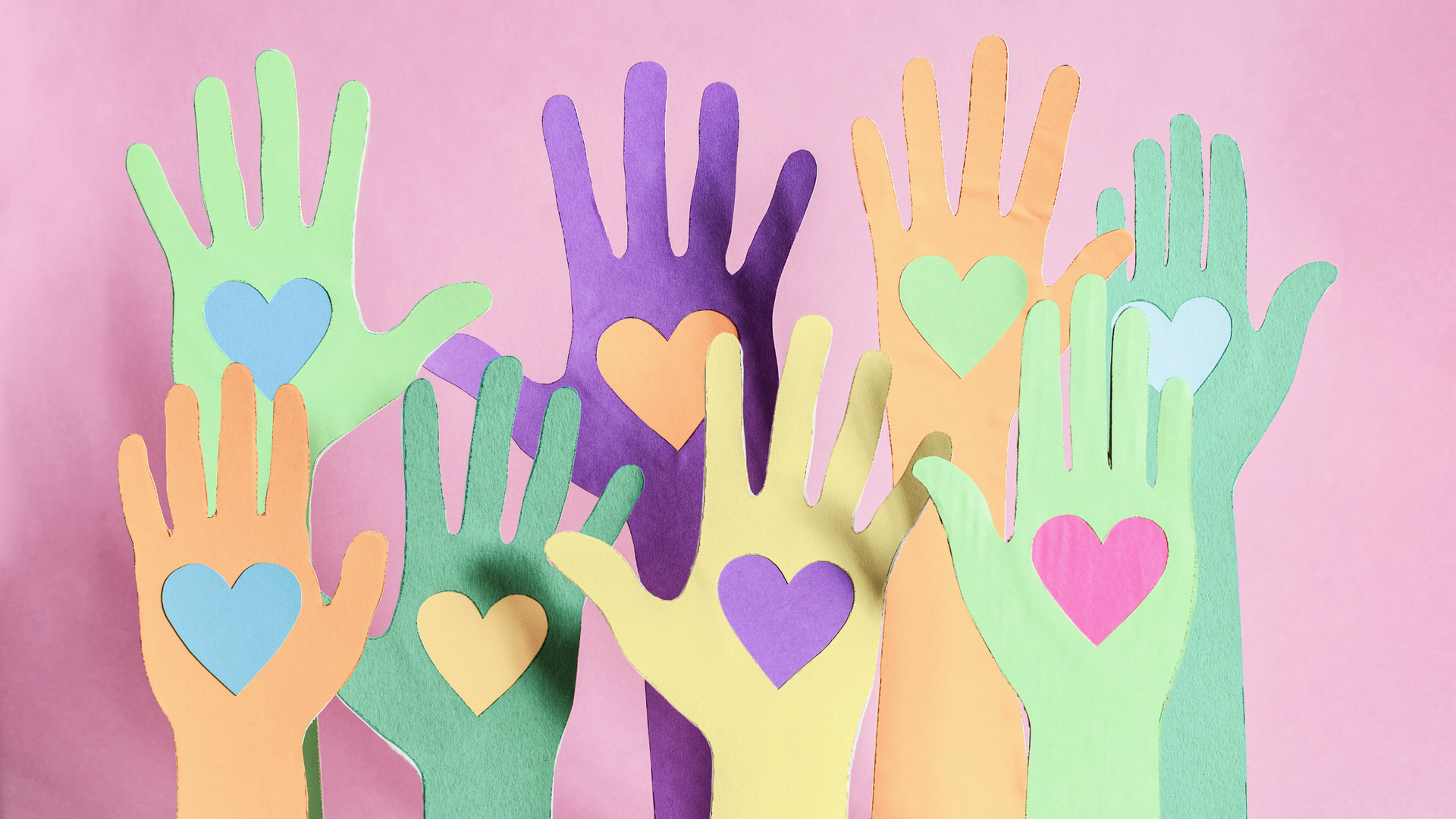 Image of paper hands with hearts cut out of them