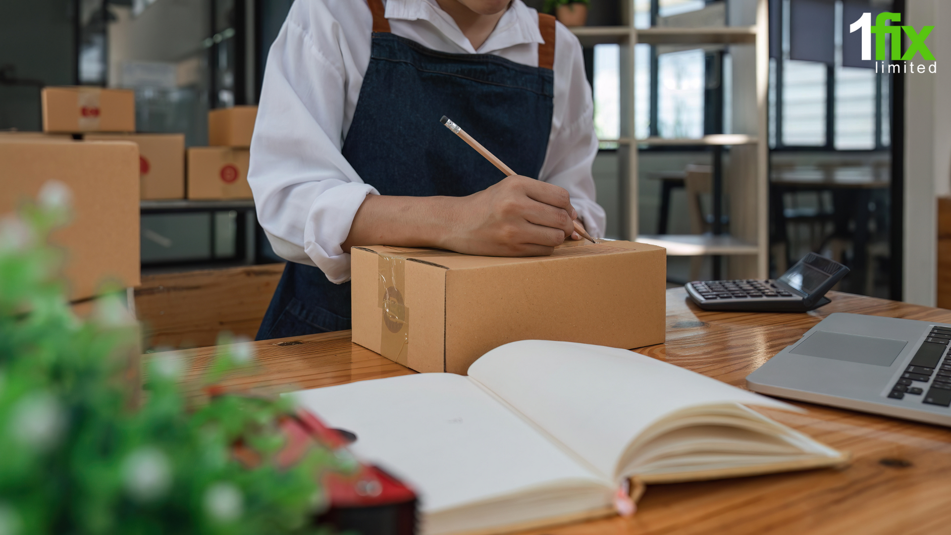 Photo of someone in an apron writing a postage label on a shipping box.