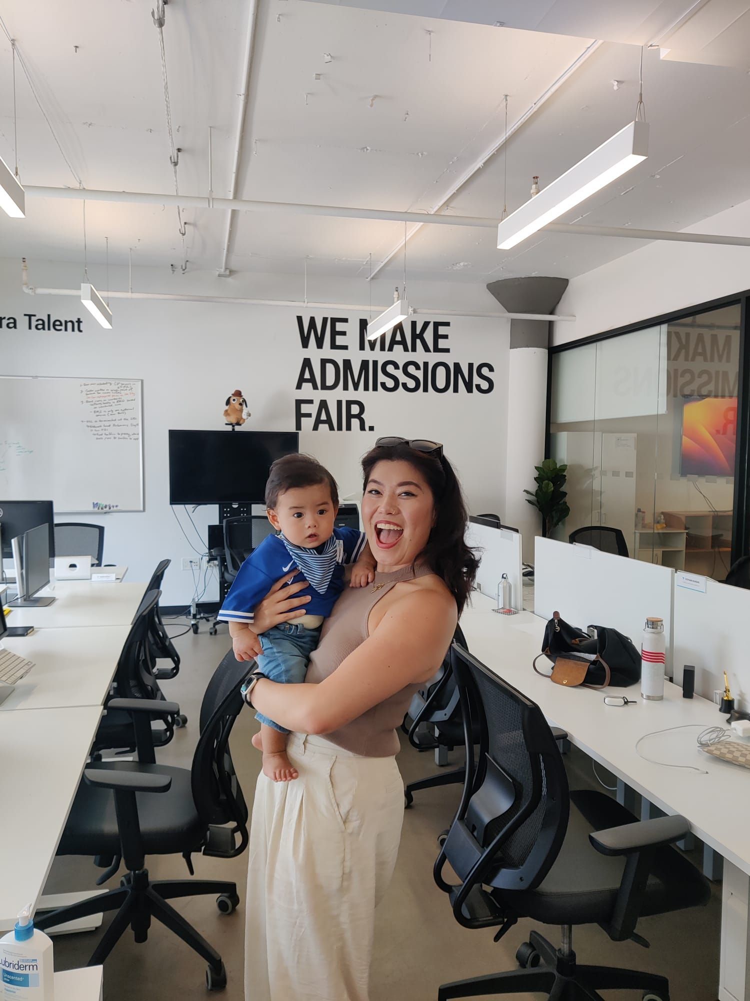 A woman is holding a baby in an office