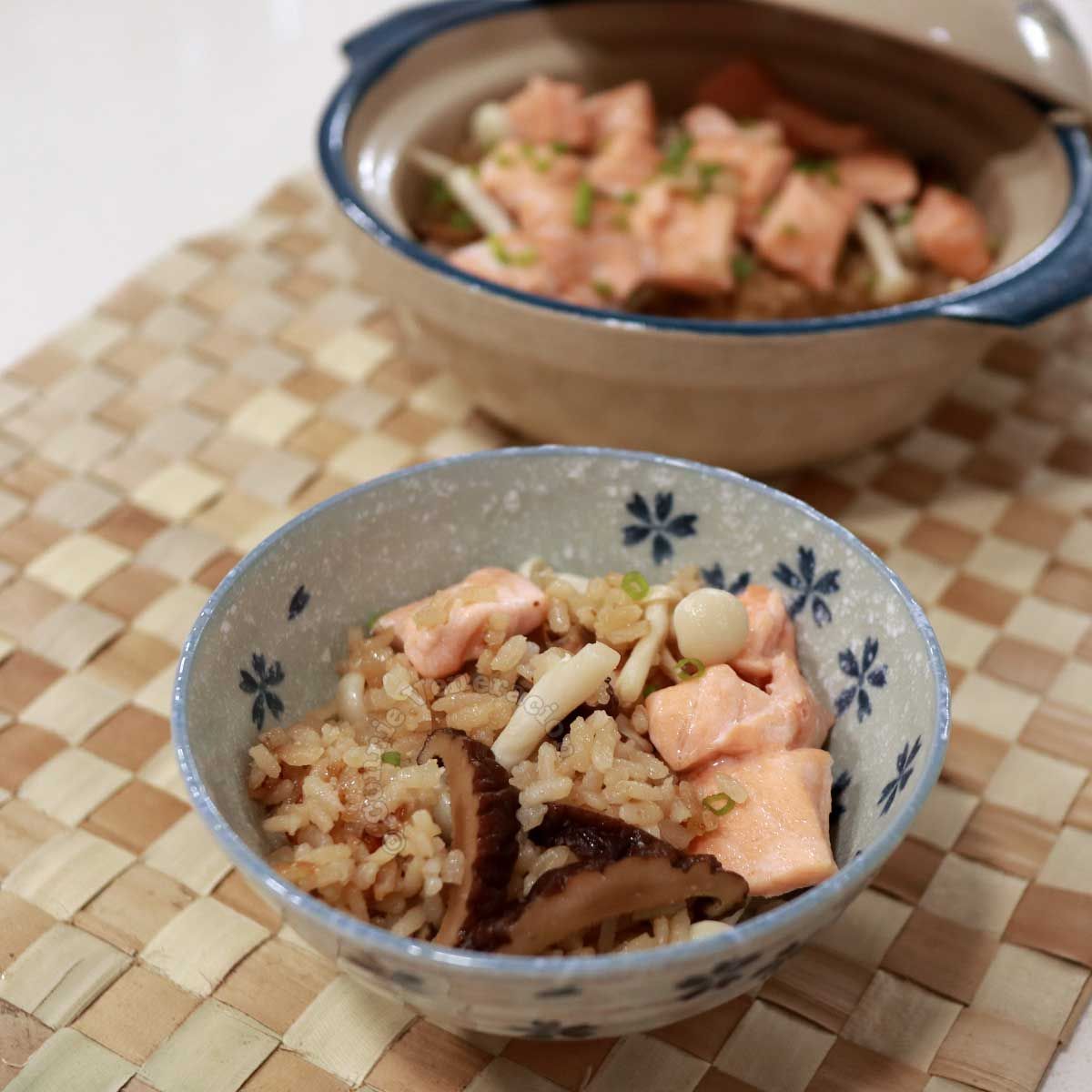 Two bowls of rice with cooked salmon and mushroom on top