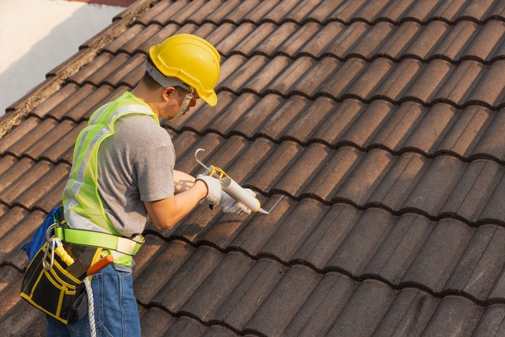 A man is standing on top of a tiled roof.