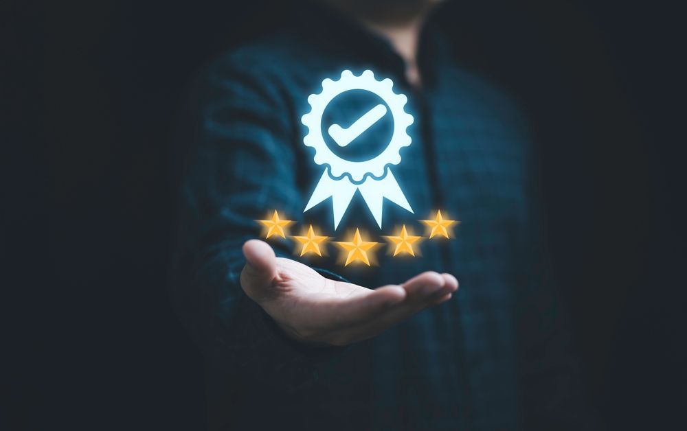 A person is holding a medal with a check mark and five stars.