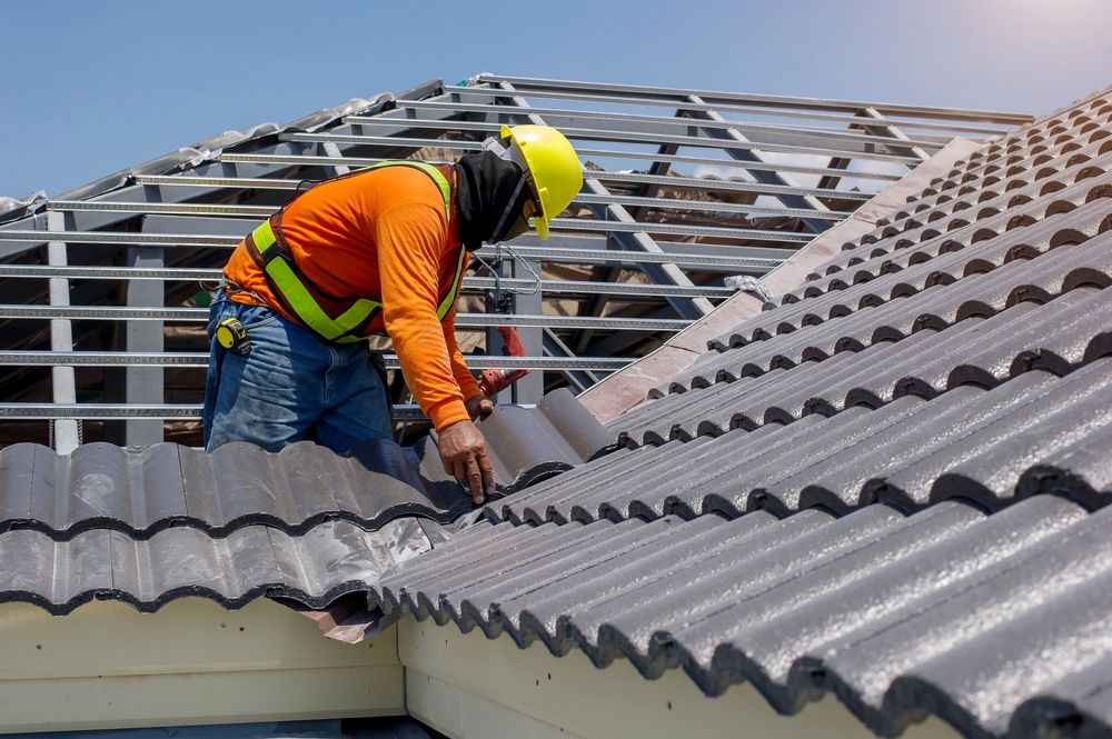 A construction worker is working on the roof of a building.