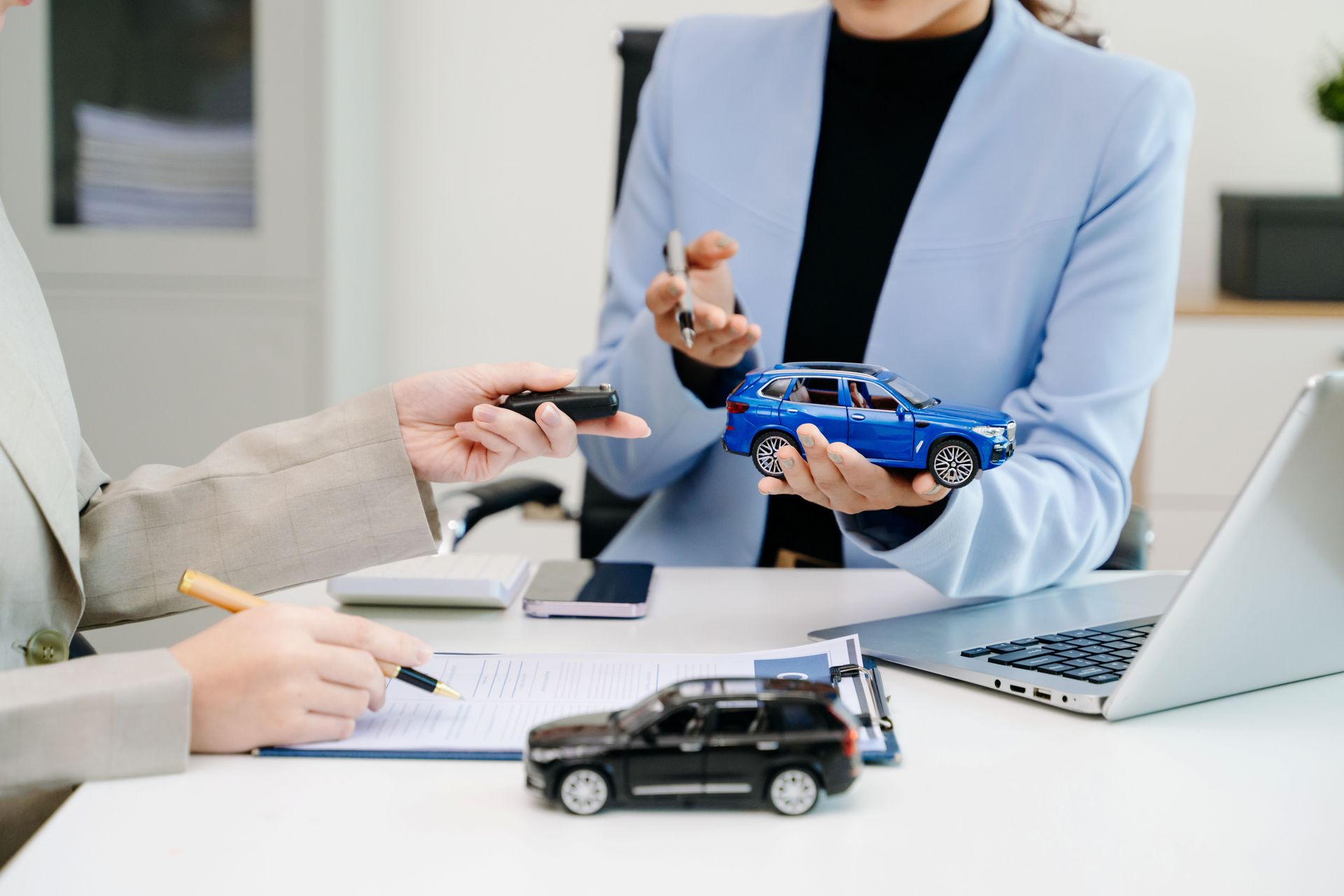 Close-up of a businesswoman discussing car models for an auto insurance broker consultation.