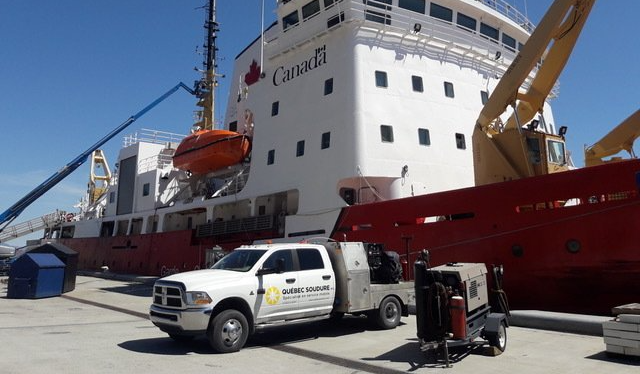 Un camion est garé devant un grand navire canadien