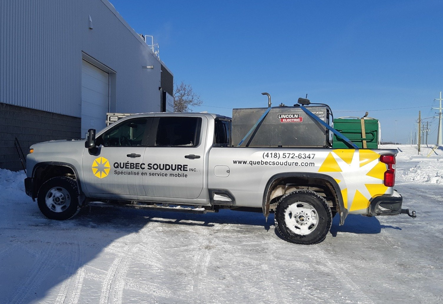 Un camion avec une étoile jaune à l'arrière est garé dans la neige.