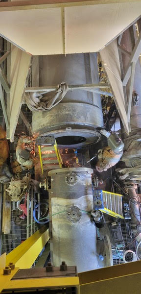 Une grosse machine est assise à l'intérieur d'un bâtiment.