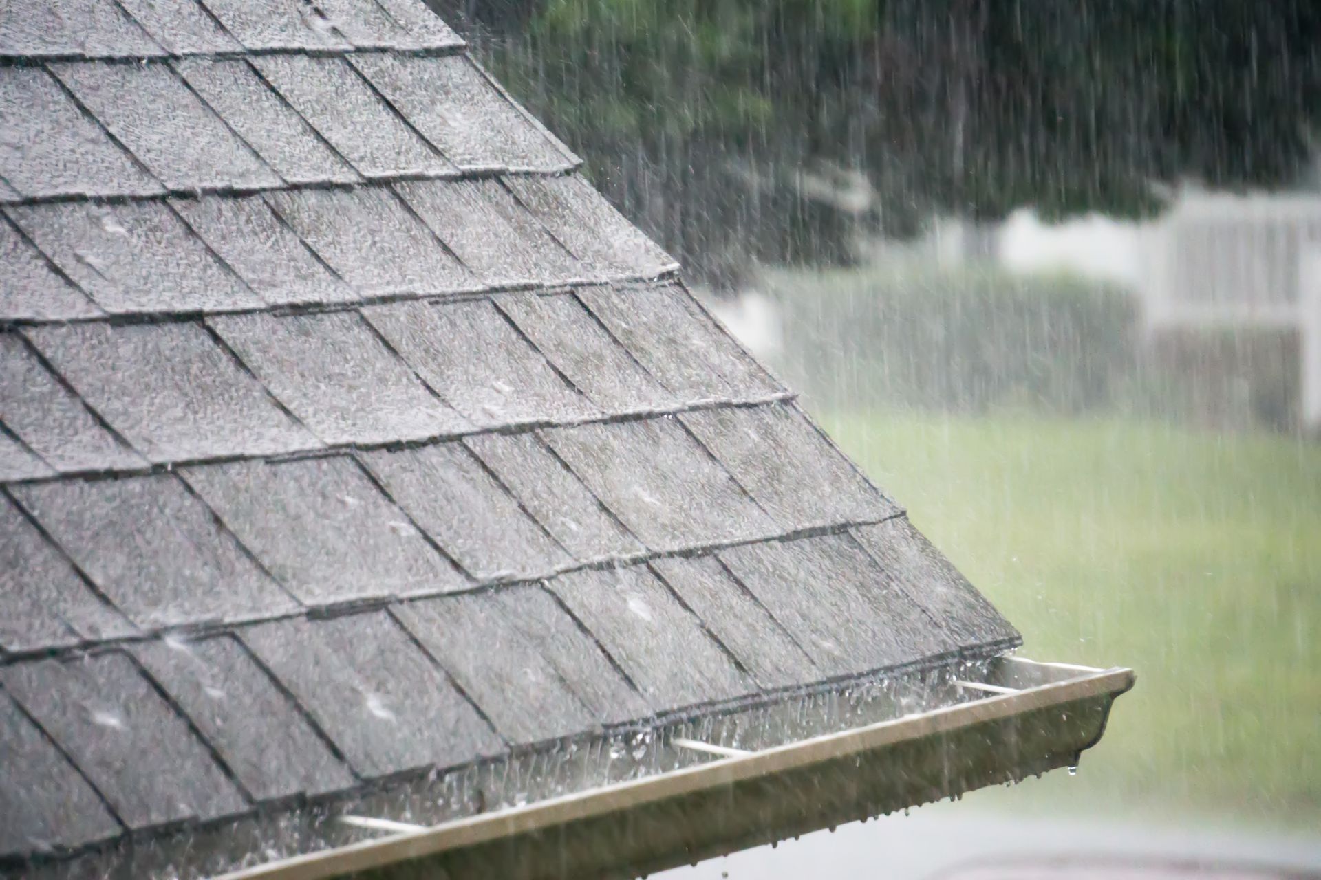 It is raining on the roof of a house.