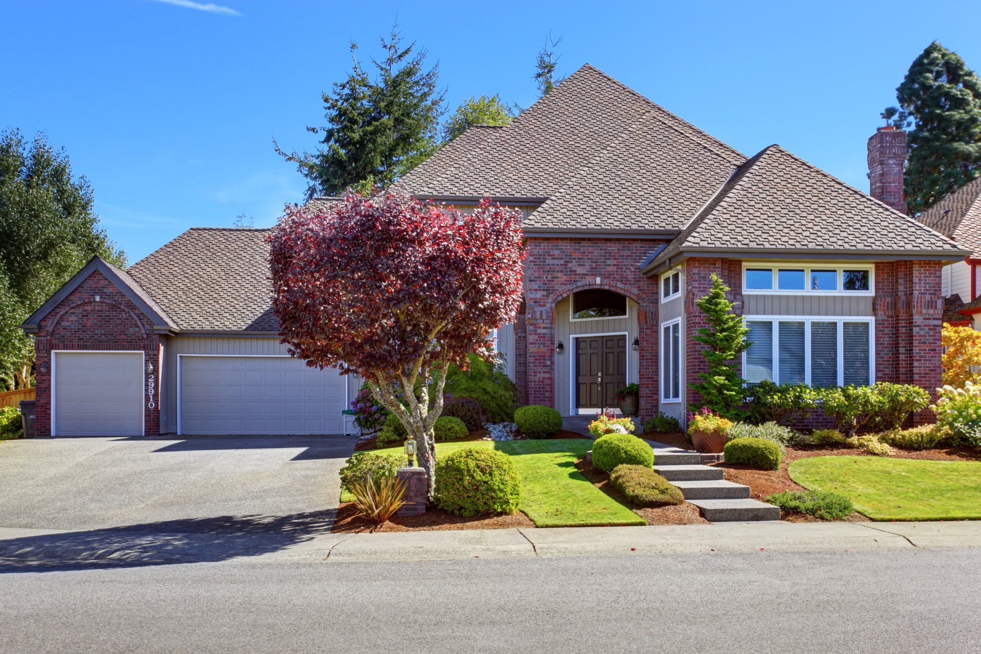 A large brick house with a tree in front of it