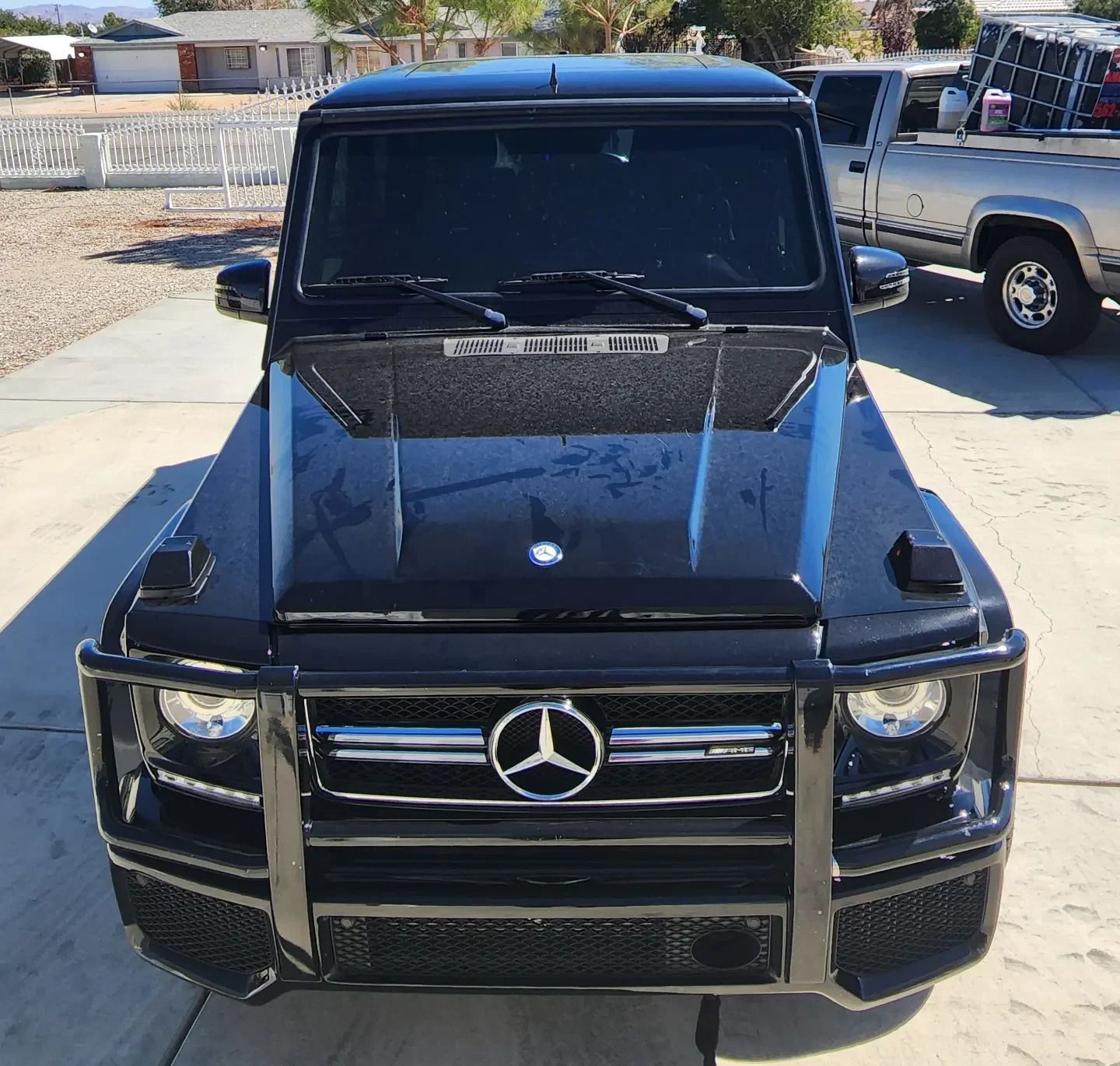 A black mercedes is parked on the side of the road