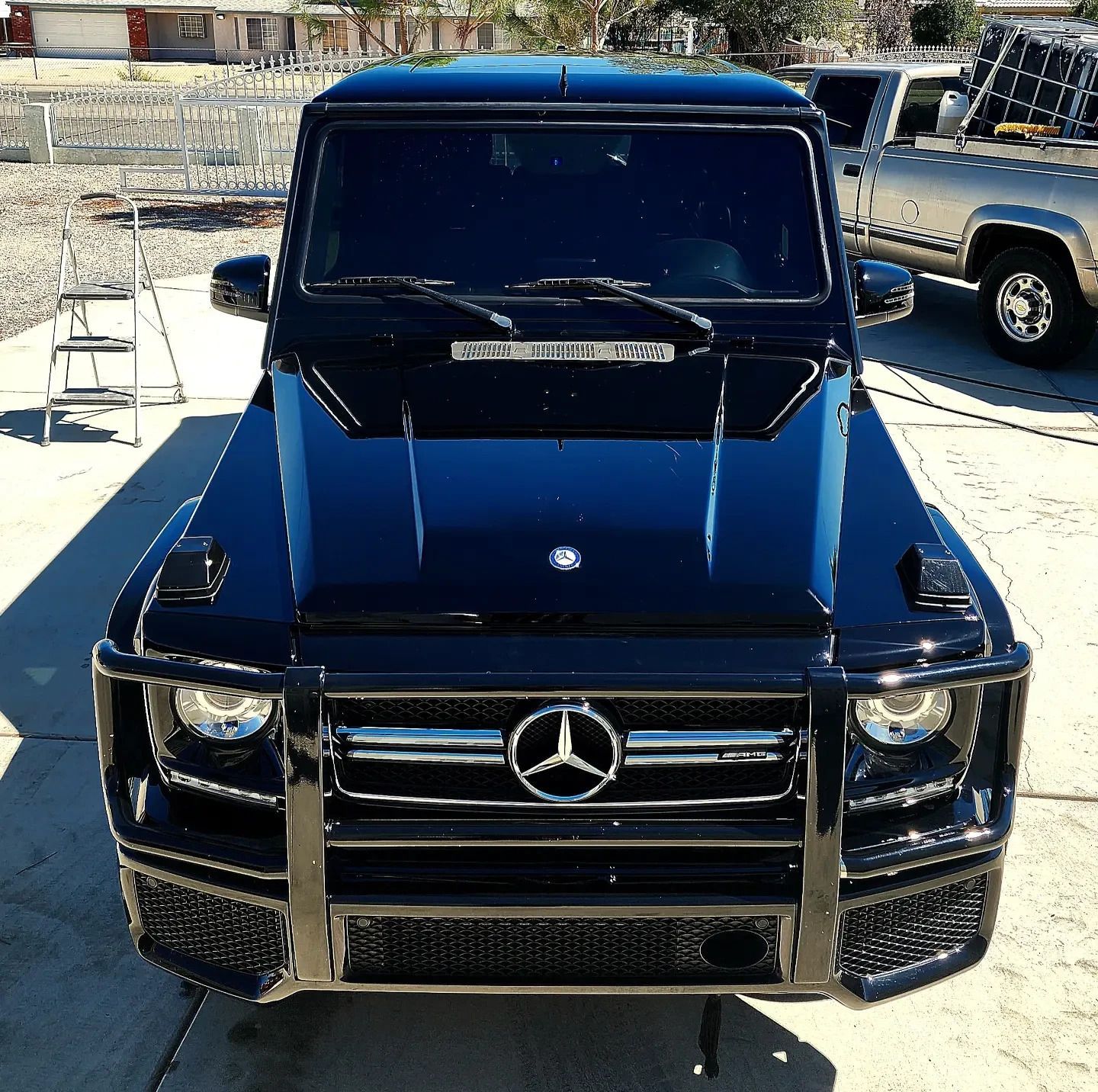 A black mercedes is parked in a parking lot