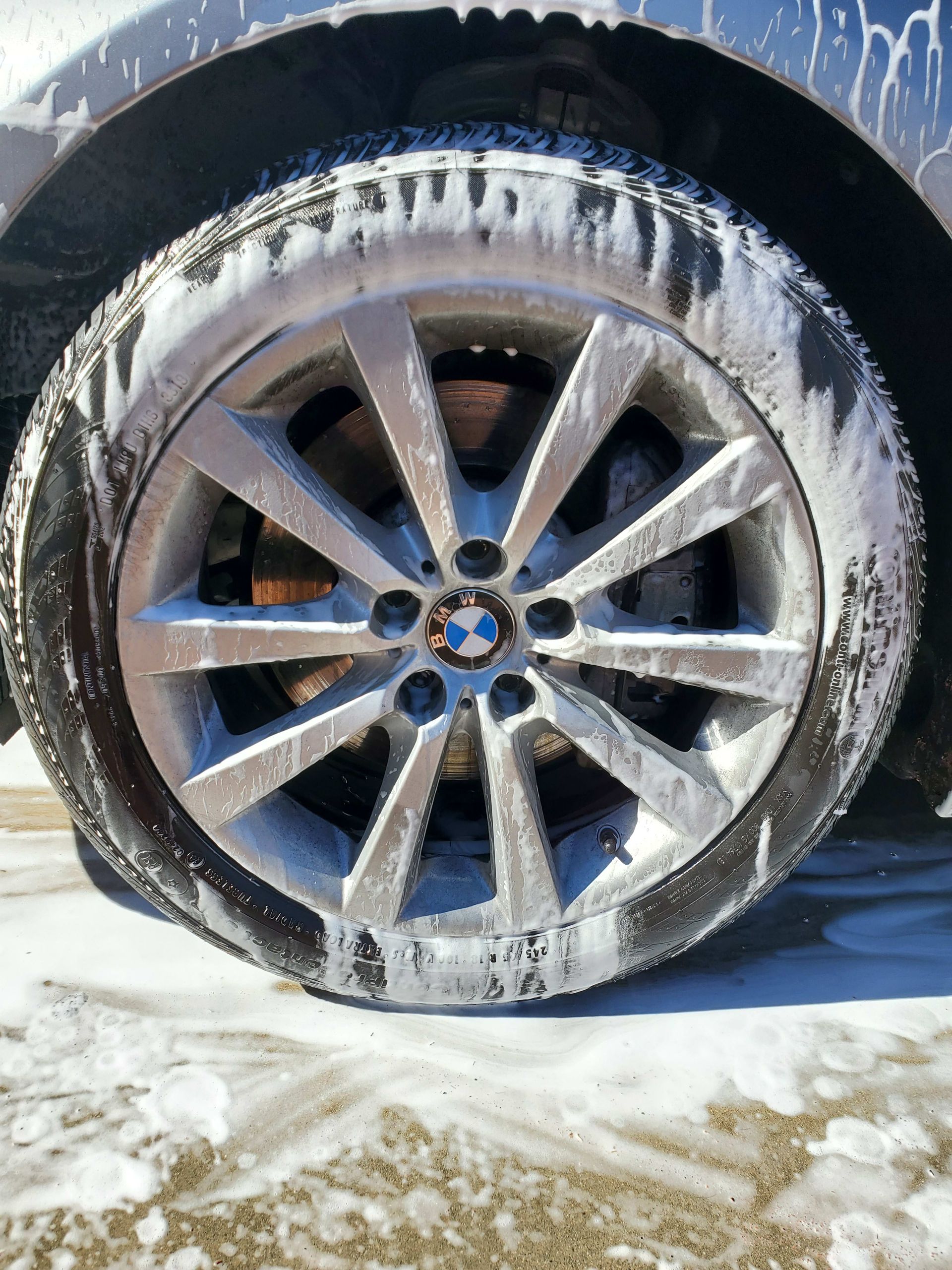 A close up of a car wheel covered in foam.