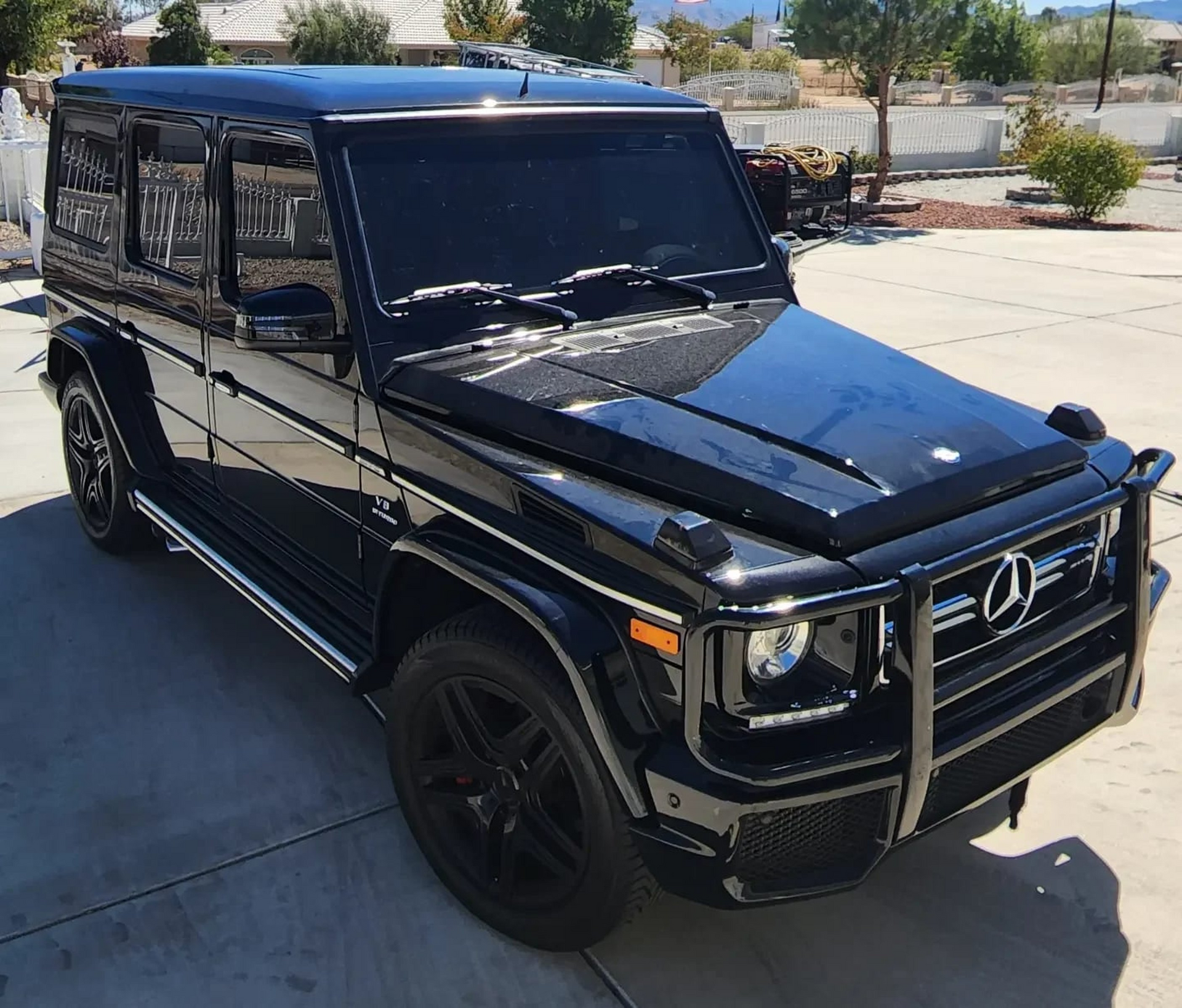 A black mercedes benz is parked in a parking lot