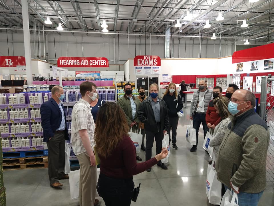 A group of people wearing face masks are standing in a store.
