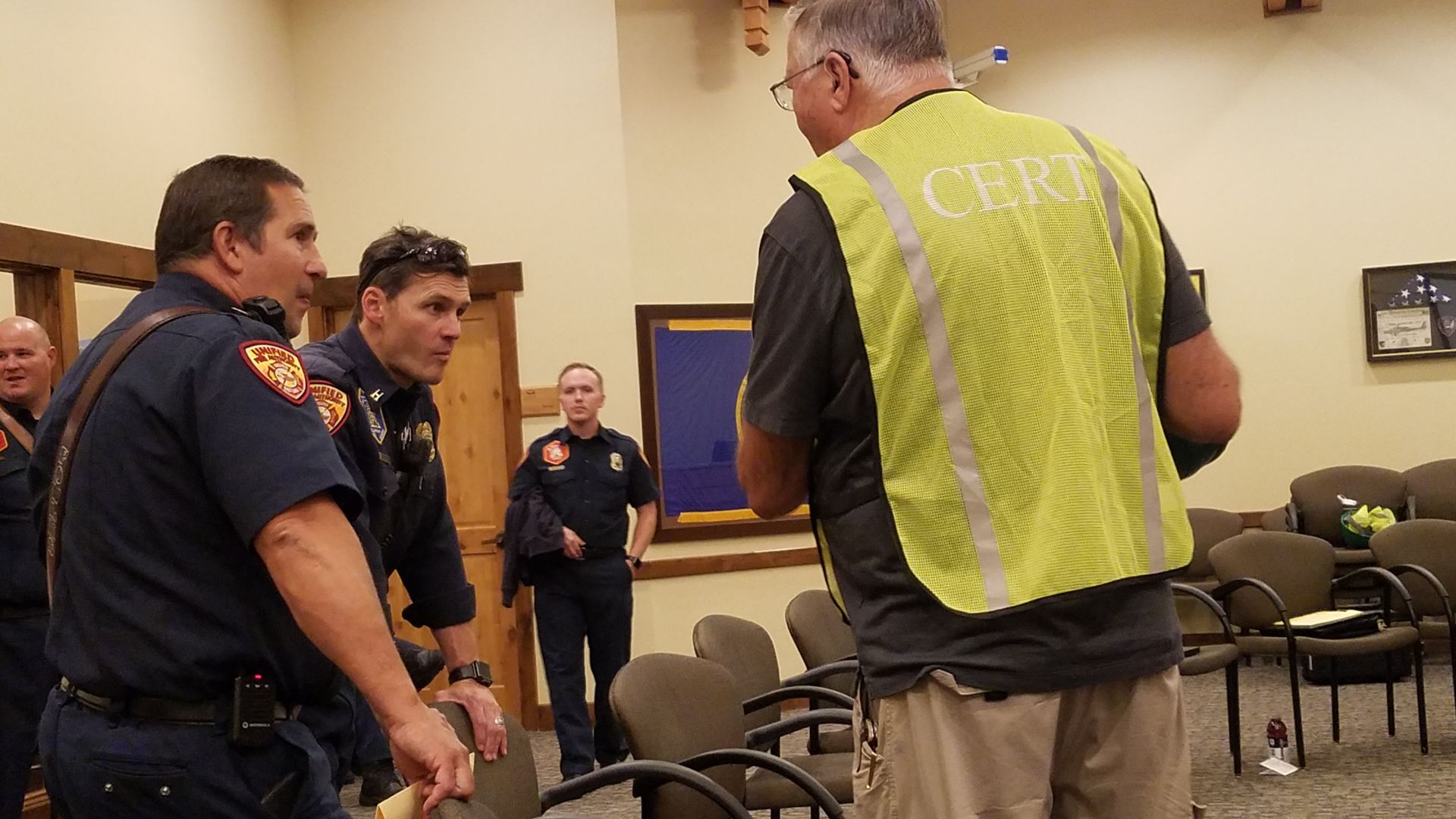 A man wearing a yellow vest with the word cbt on it