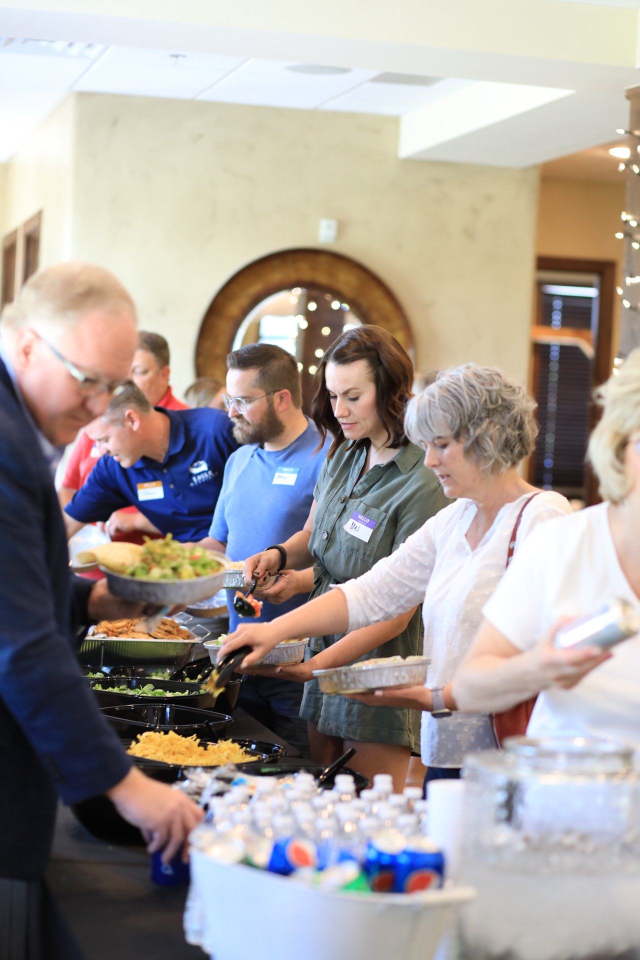 A group of people are standing at a buffet line.