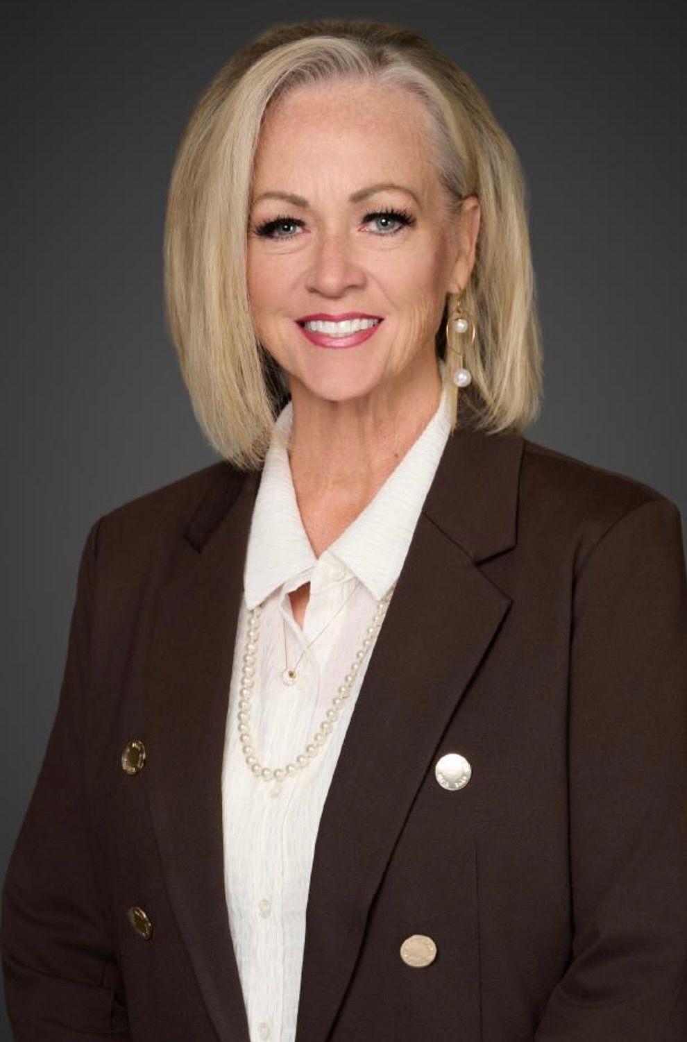 A woman with a braided ponytail is standing in front of a blue sky.