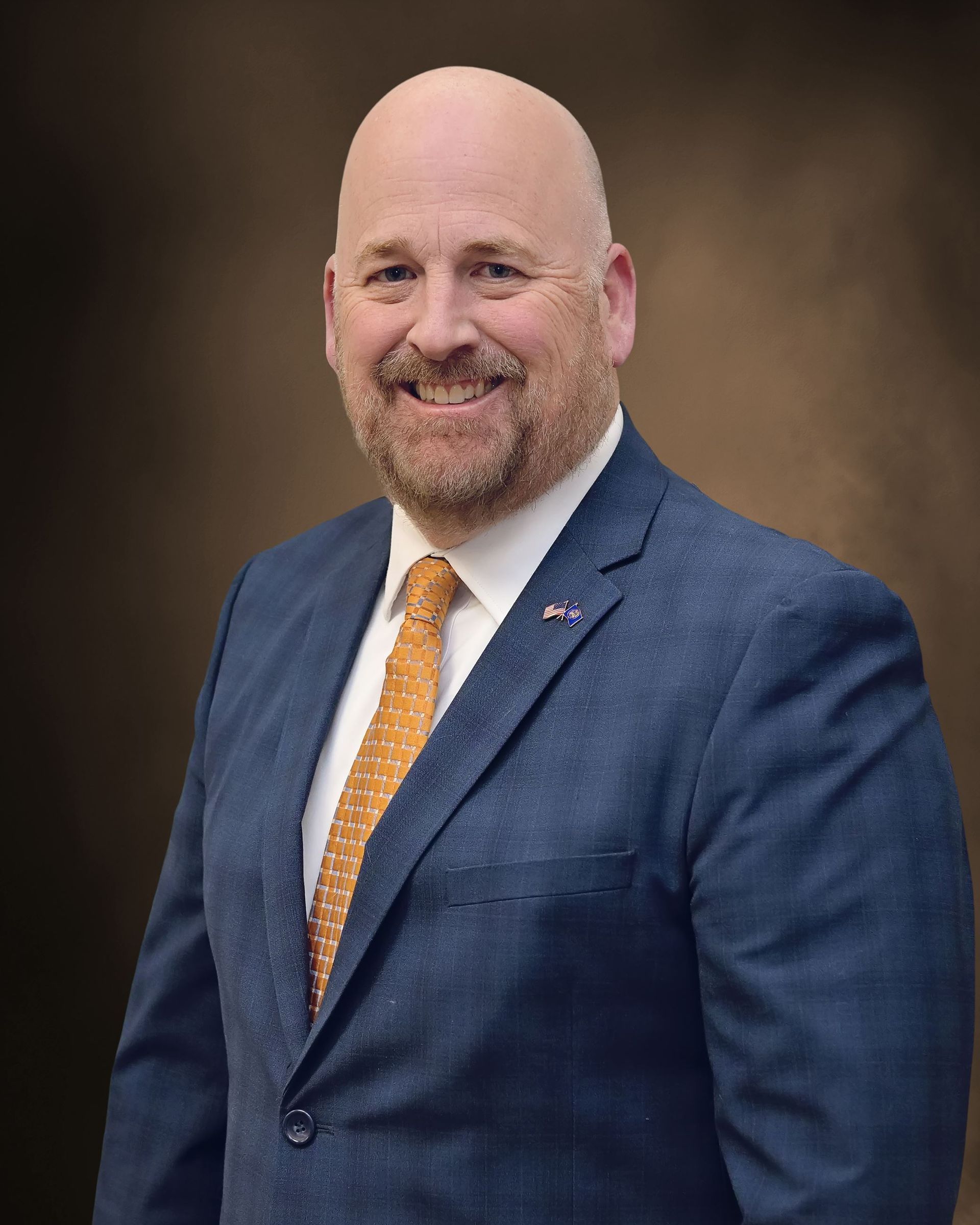 A man in a suit and tie is smiling for the camera.