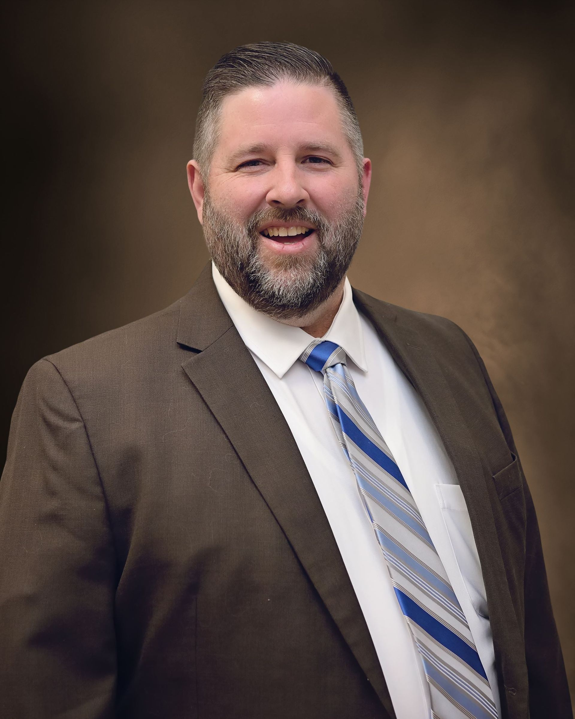 A man in a suit and tie is smiling for the camera.