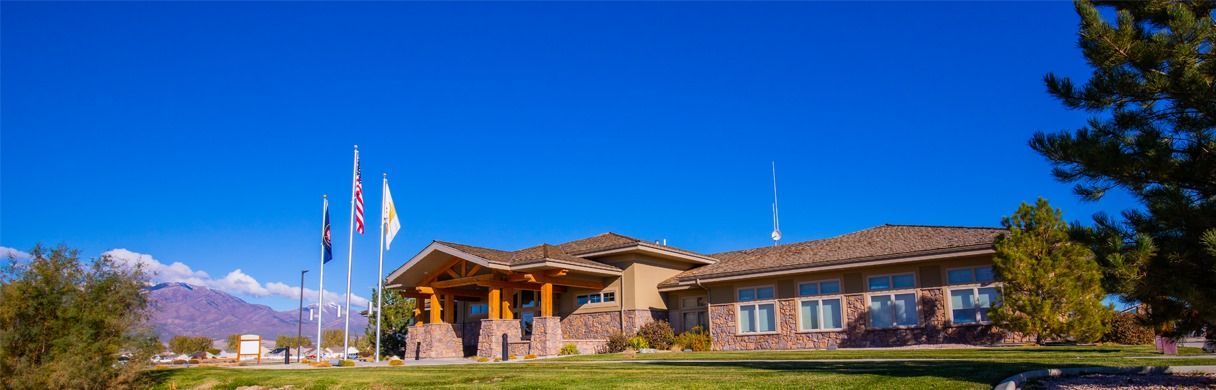 A large house with flags flying in front of it on a sunny day.